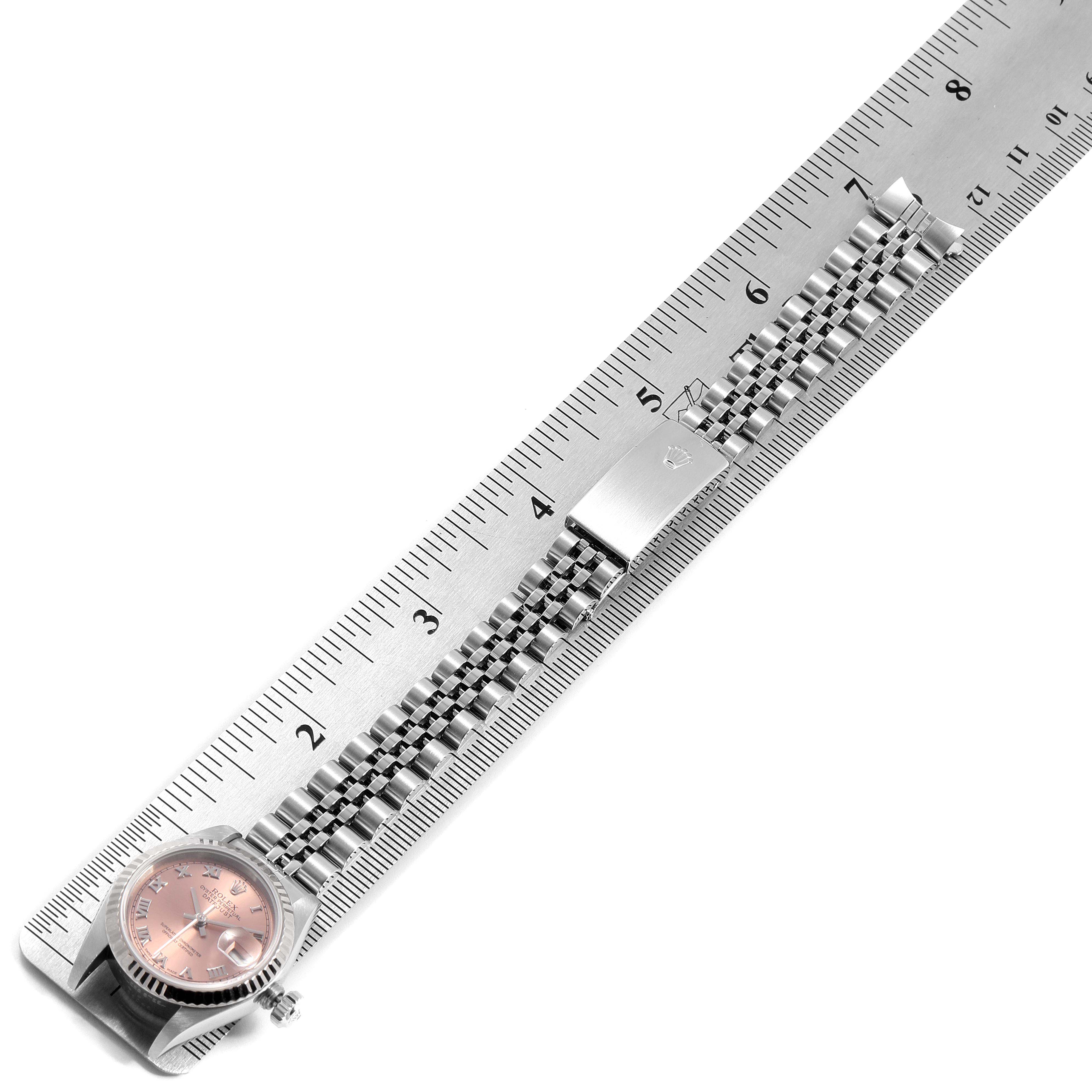 The image shows a Rolex Datejust 79174 Women's Stainless Steel Pink Dial 79174 Women's Stainless Steel Pink Dial watch laid parallel to a ruler, highlighting its bracelet and clasp.