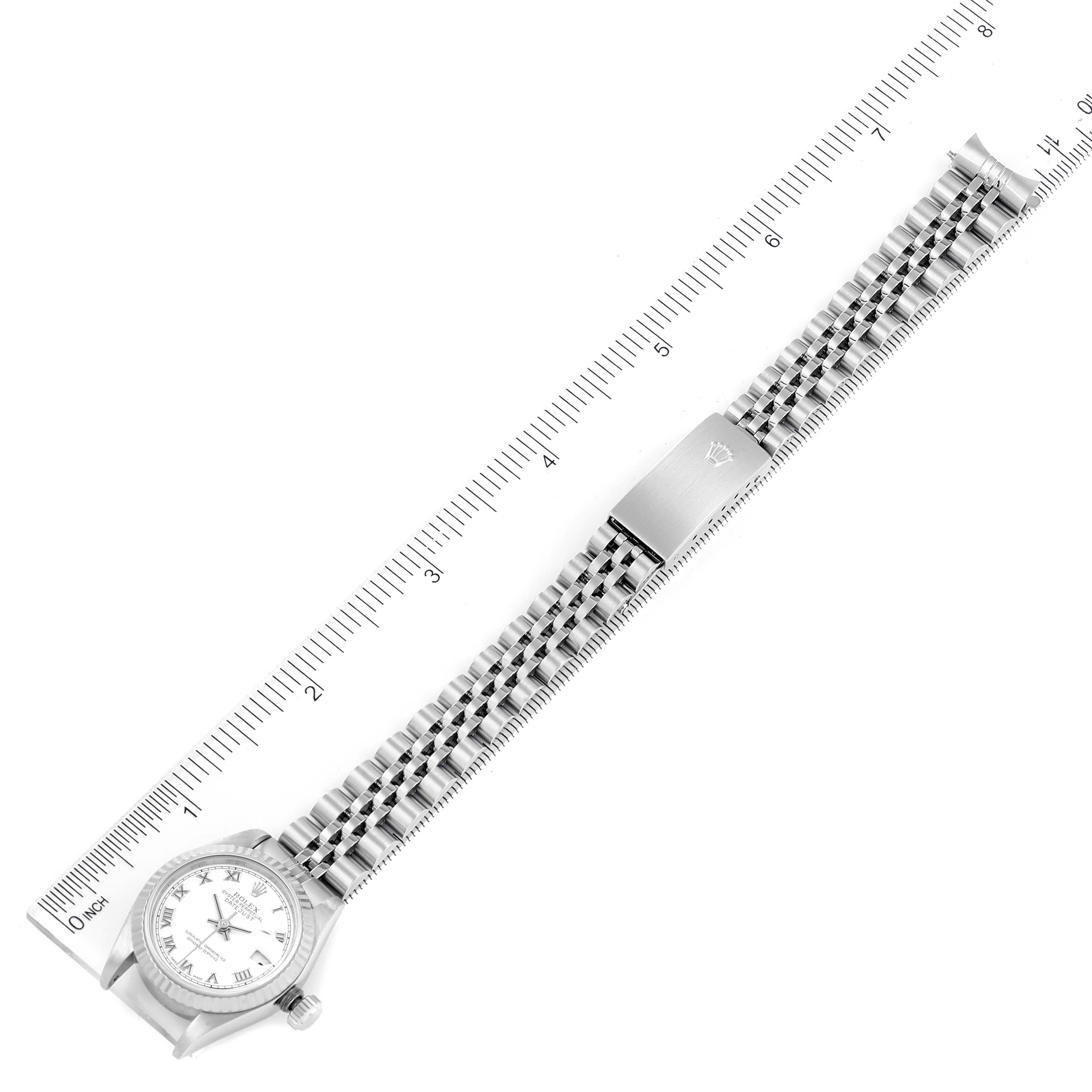 The image shows a top view of a Rolex Datejust 79174 Women's Stainless Steel White Dial 79174 Women's Stainless Steel White Dial watch, including its bracelet, clasp, and face, against a ruler for scale.