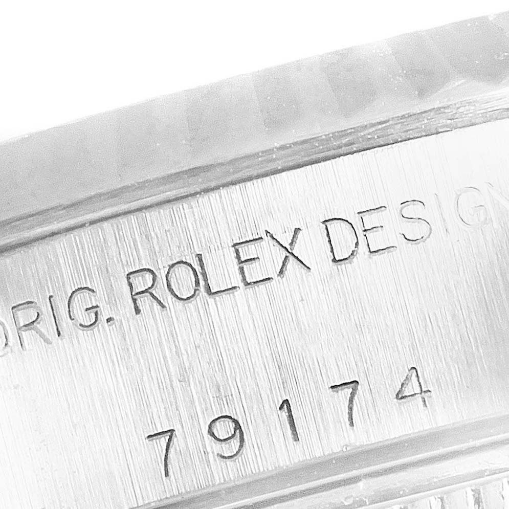 The image shows a close-up of the Rolex Datejust 79174 Women
s Stainless Steel Mother of Pearl Dial 79174 Women
s Stainless Steel Mother of Pearl Dial watch
s case side with engraved model number and "ROLEX DESIGN" text.