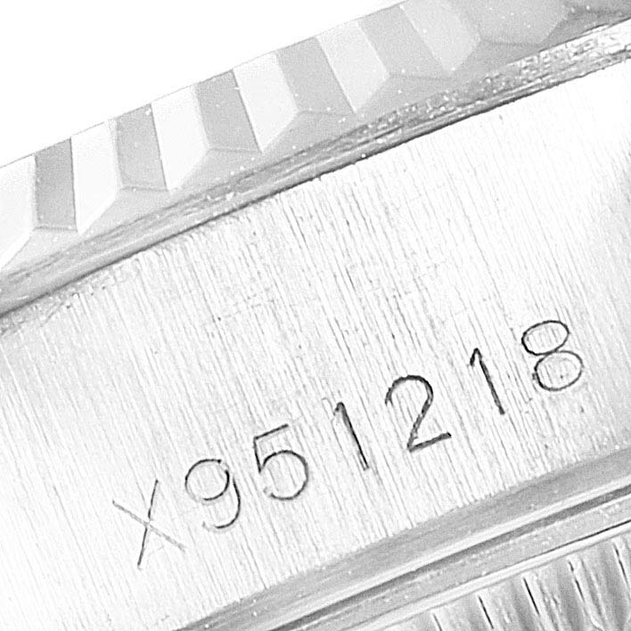 This image shows a close-up of the serial number engraving and part of the fluted bezel of a Rolex Datejust 69174 Women
s Stainless Steel Silver Dial 69174 Women
s Stainless Steel Silver Dial watch.