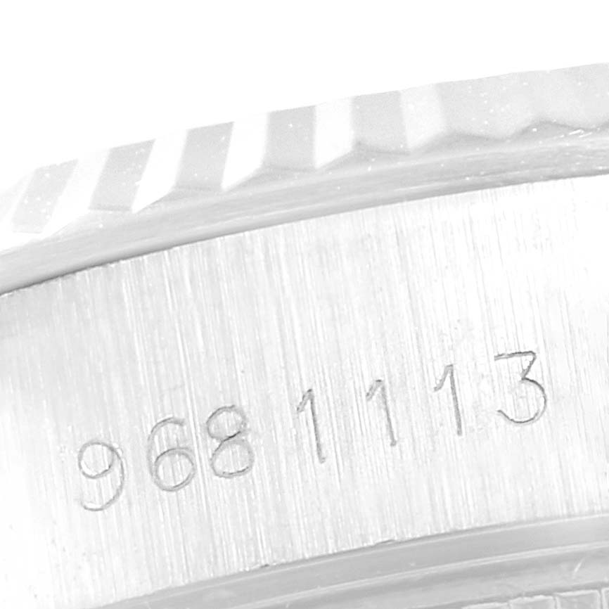 The image shows a close-up of the side of the Rolex Datejust 69174 Women
s Stainless Steel Silver Dial 69174 Women
s Stainless Steel Silver Dial watch case with engraved numbers, including part of the bezel.