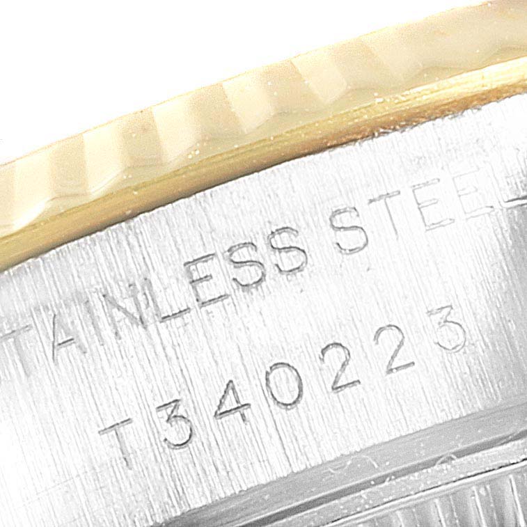 This close-up shows the side view of a Rolex Datejust 69173 Women
s Steel and Gold (two tone) Black Dial 69173 Women
s Steel and Gold (two tone) Black Dial watch, highlighting the serial number and engraved stainless steel text.