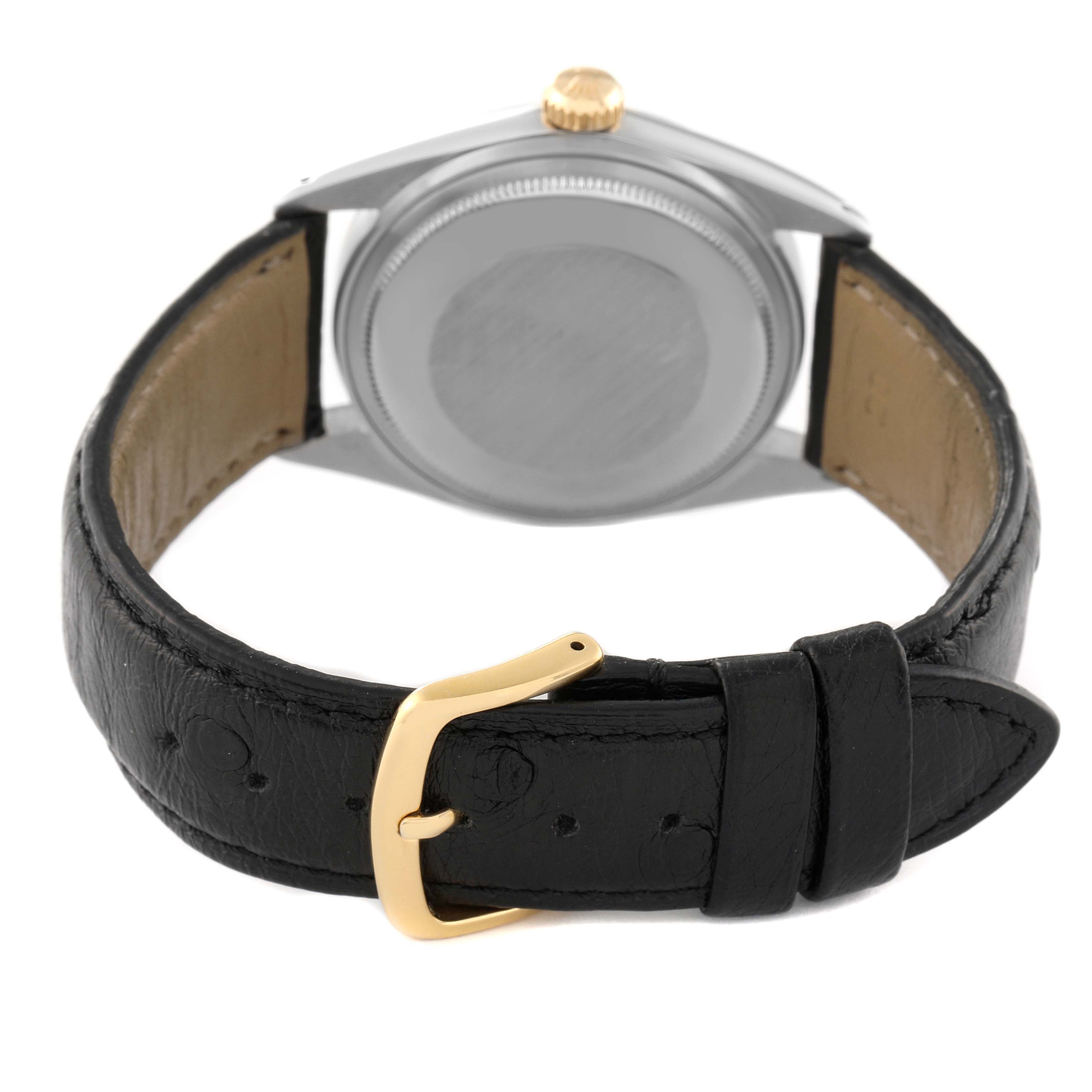 The image shows the back of the Rolex Vintage Collection 1601 Men
s Steel and Gold (two tone) Champagne Dial 1601 Men
s Steel and Gold (two tone) Champagne Dial watch with a black leather strap and a gold buckle.