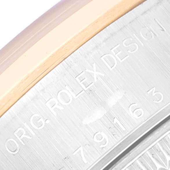 This image shows a close-up angle of the engraved details on the bezel and case of a Rolex Datejust 79163 Women's Steel and Gold (two tone) Black Dial 79163 Women's Steel and Gold (two tone) Black Dial watch.