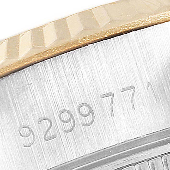 The image shows a close-up of the Rolex Datejust 69173 Women
s Steel and Gold (two tone) Champagne Dial 69173 Women
s Steel and Gold (two tone) Champagne Dial bezel and part of the case with a visible serial number.