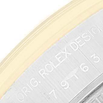 This close-up image shows the side of the case of a Rolex Datejust 79163 Women
s Steel and Gold (two tone) Grey Dial 79163 Women
s Steel and Gold (two tone) Grey Dial, including the edge of the bezel and engravings.