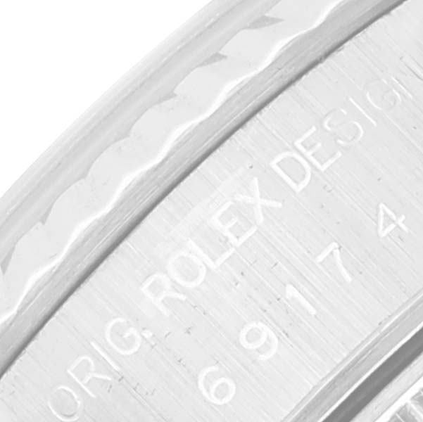 This close-up image shows the engraved text on the side of the case back of a Rolex Datejust 69174 Women's Stainless Steel Silver Dial 69174 Women's Stainless Steel Silver Dial watch.