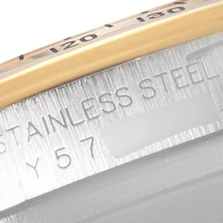 This image shows a close-up of the side of a Rolex Daytona 116523 Men's Steel and Gold (two tone) Black Dial 116523 Men's Steel and Gold (two tone) Black Dial watch case, highlighting the "Stainless Steel" engraving and part of the bezel.