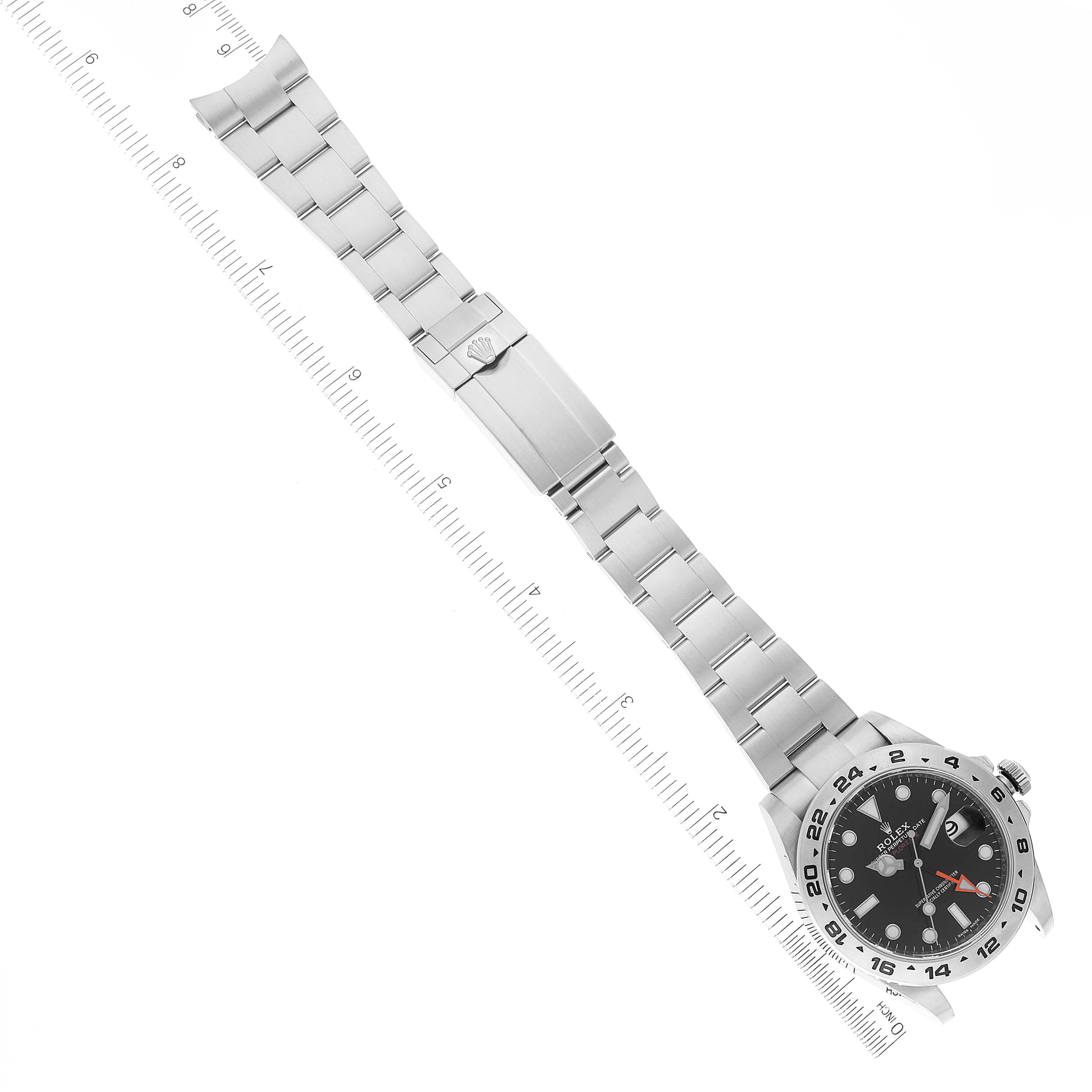 The image shows a top-down view of a Rolex Explorer 216570 Men's Stainless Steel Black Dial 216570 Men's Stainless Steel Black Dial watch, with its bracelet fully extended and a ruler for scale.