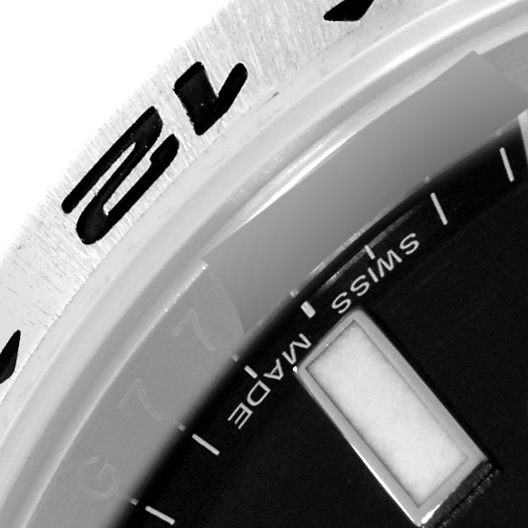 The image shows a close-up of the bezel and part of the dial of a Rolex Explorer 216570 Men's Stainless Steel Black Dial 216570 Men's Stainless Steel Black Dial watch, including the "Swiss Made" text.