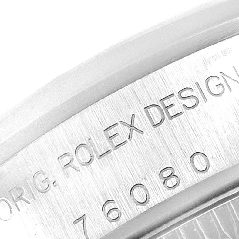 This image shows a close-up of the engraved serial number and "Rolex Design" on the case back of a Rolex Oyster Perpetual 76080 Women's Stainless Steel Pink Dial 76080 Women's Stainless Steel Pink Dial watch.
