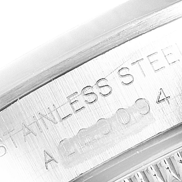 The image shows a close-up of the serial number and "STAINLESS STEEL" engraving on the side of a Rolex Oyster Perpetual 76080 Women's Stainless Steel Pink Dial 76080 Women's Stainless Steel Pink Dial watch.