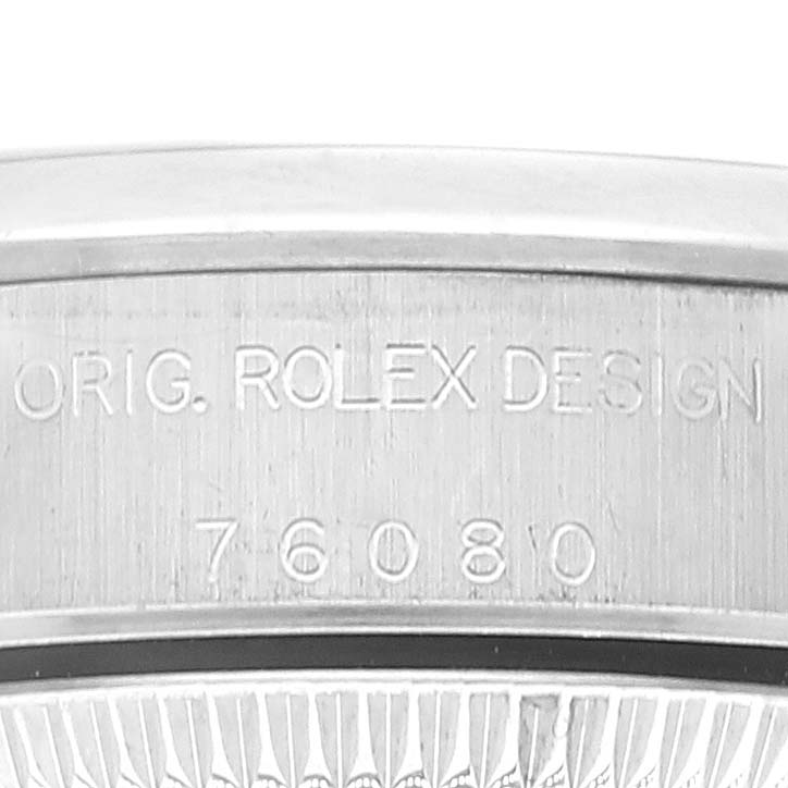 This image shows a close-up of the Oyster Perpetual Rolex watch's caseback, specifically displaying the serial number and "Original Rolex Design" engraving.