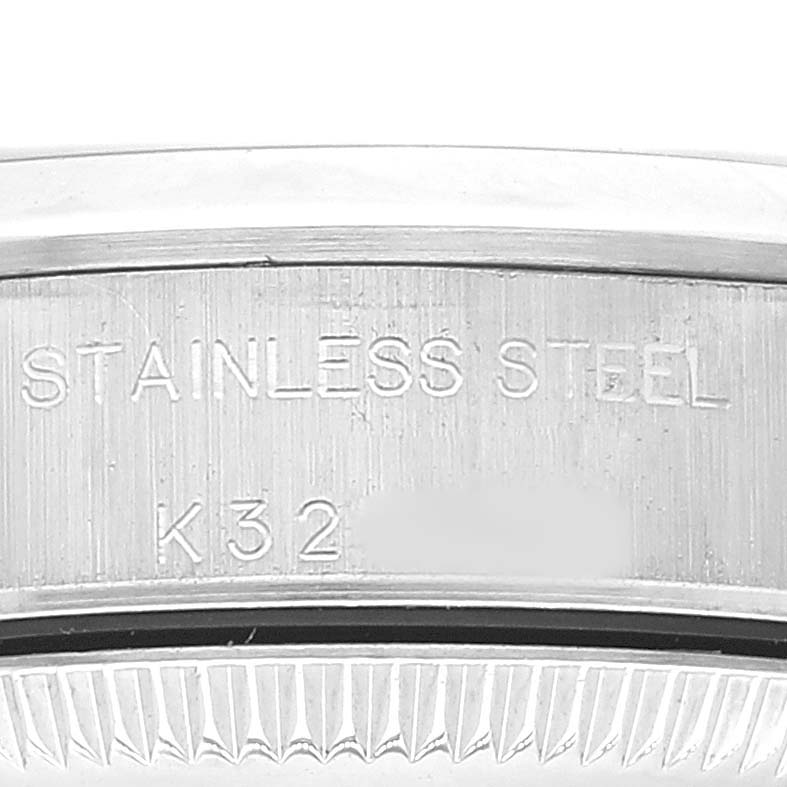 This image shows a close-up of the stainless steel case back of a Rolex Oyster Perpetual 76080 Women's Stainless Steel Black Dial 76080 Women's Stainless Steel Black Dial watch, engraved with "STAINLESS STEEL" and serial number partially visible.