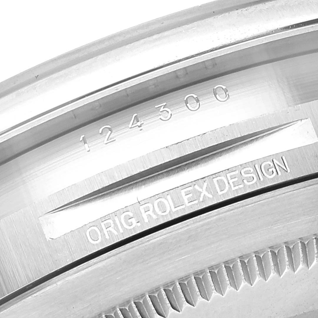 The image shows a close-up of the engraved bezel and inner case of a Rolex Oyster Perpetual 124300 Men
s Stainless Steel Blue Dial 124300 Men
s Stainless Steel Blue Dial watch, displaying the model number.