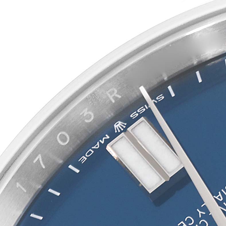 This close-up of a Rolex Oyster Perpetual 124300 Men
s Stainless Steel Blue Dial 124300 Men
s Stainless Steel Blue Dial watch shows the edge of the dial, minute markers, hour markers, and part of the minute hand.