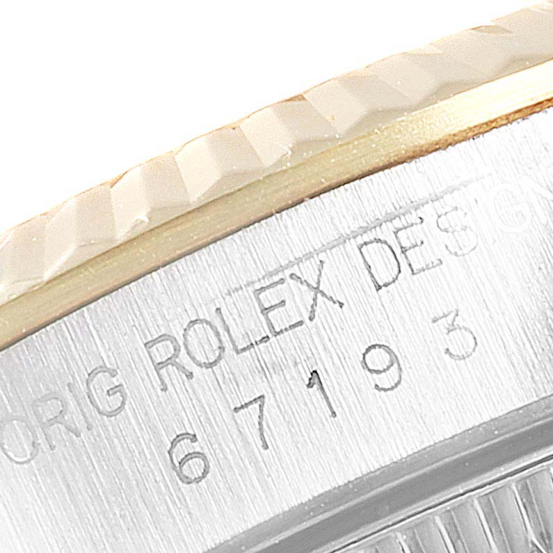 The image shows a close-up of the engraved side of the bezel and lugs on a Rolex Oyster Perpetual 67193 Women's Steel and Gold (two tone) Champagne Dial 67193 Women's Steel and Gold (two tone) Champagne Dial watch.