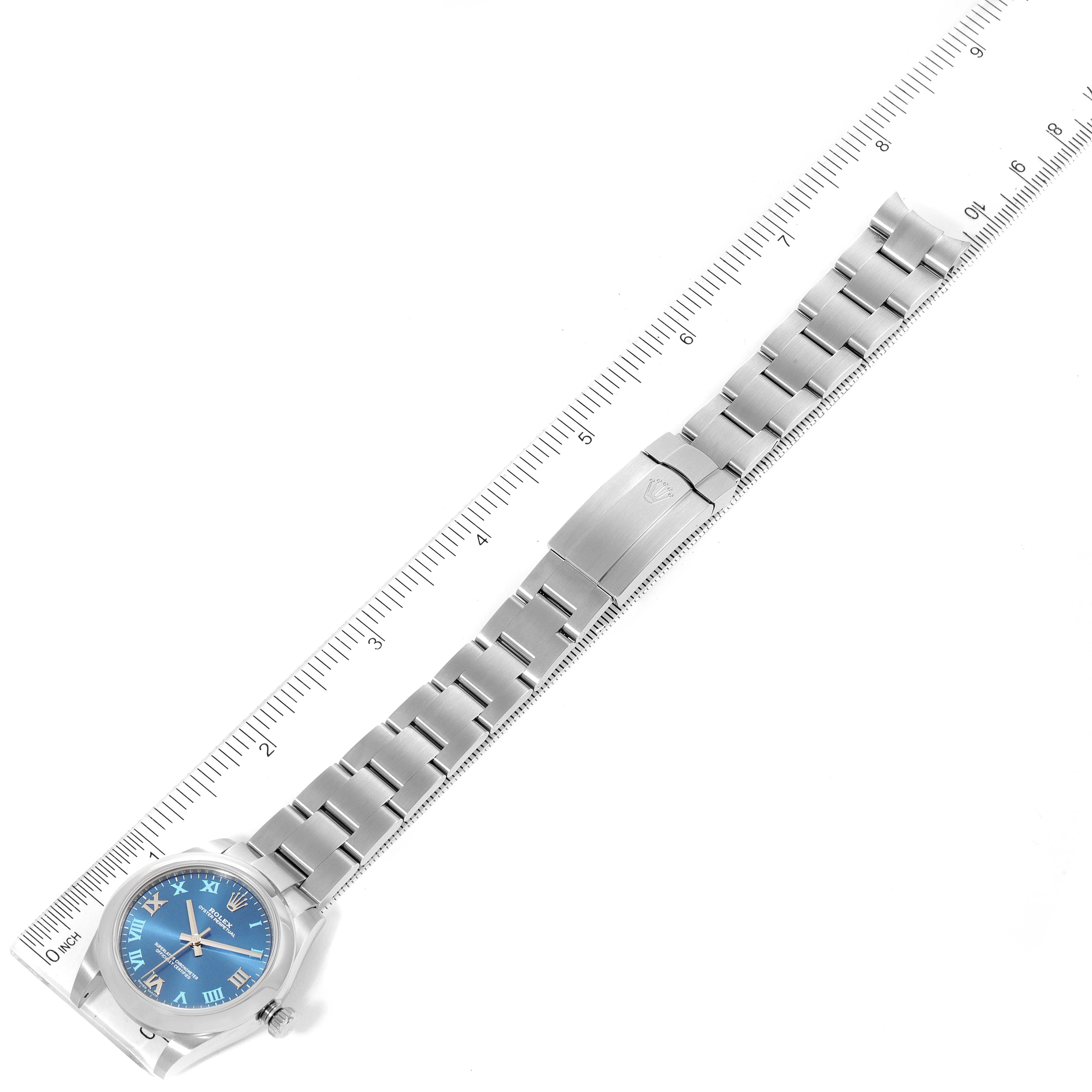 The image shows the Rolex Mid-Size 177200 Women's Stainless Steel Blue Dial 177200 Women's Stainless Steel Blue Dial model watch laid flat, displaying its blue dial, case, and full metal bracelet alongside a measuring ruler.