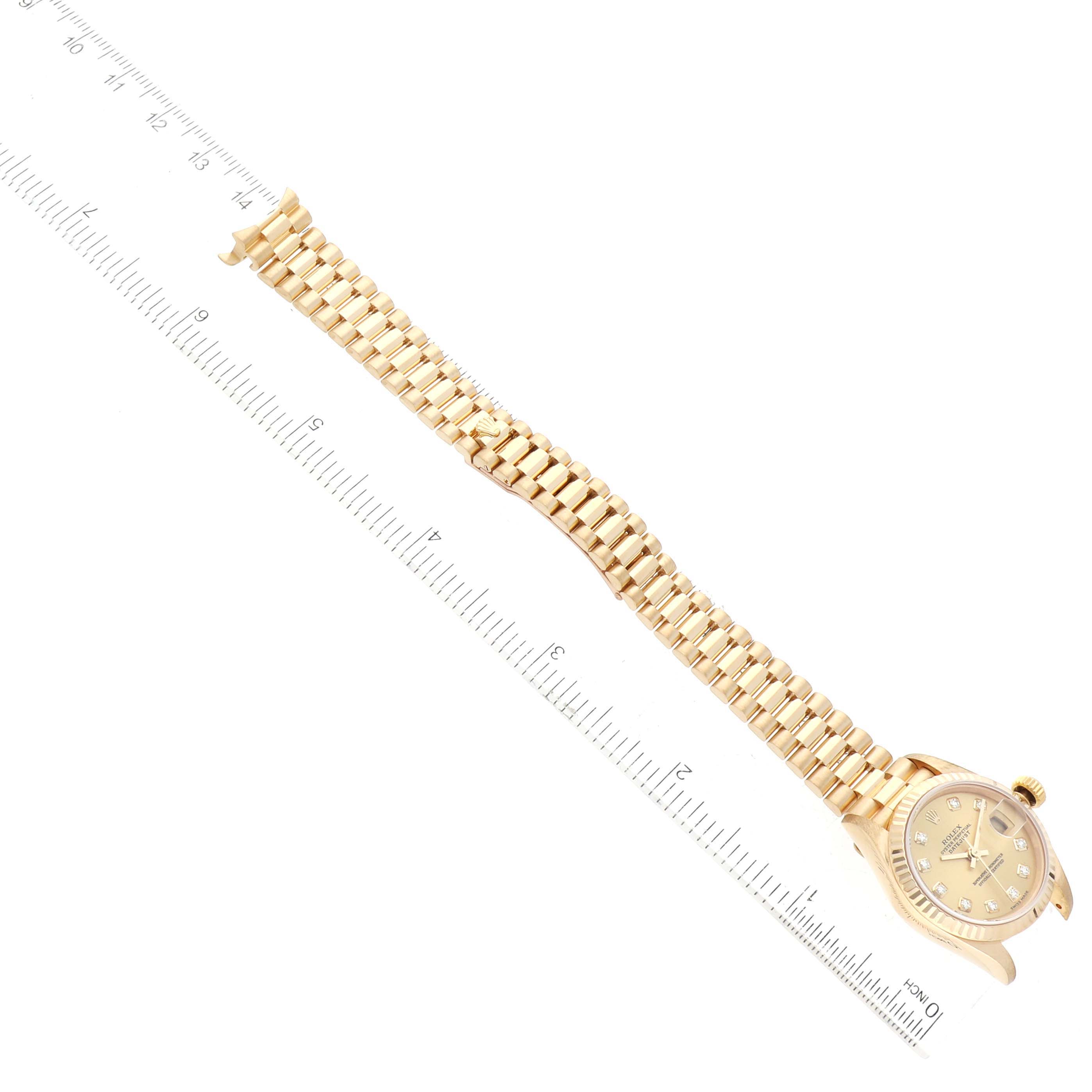 The image shows a Rolex President 79178 Women's Yellow Gold Champagne Dial 79178 Women's Yellow Gold Champagne Dial model watch laid flat with its gold bracelet and dial face visible, alongside a measuring ruler.