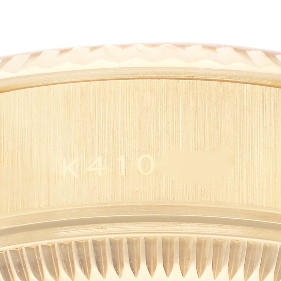 This close-up image shows the side of the bezel and case band of a Rolex President 79178 Women's Yellow Gold Champagne Dial 79178 Women's Yellow Gold Champagne Dial model watch, revealing part of its serial number.