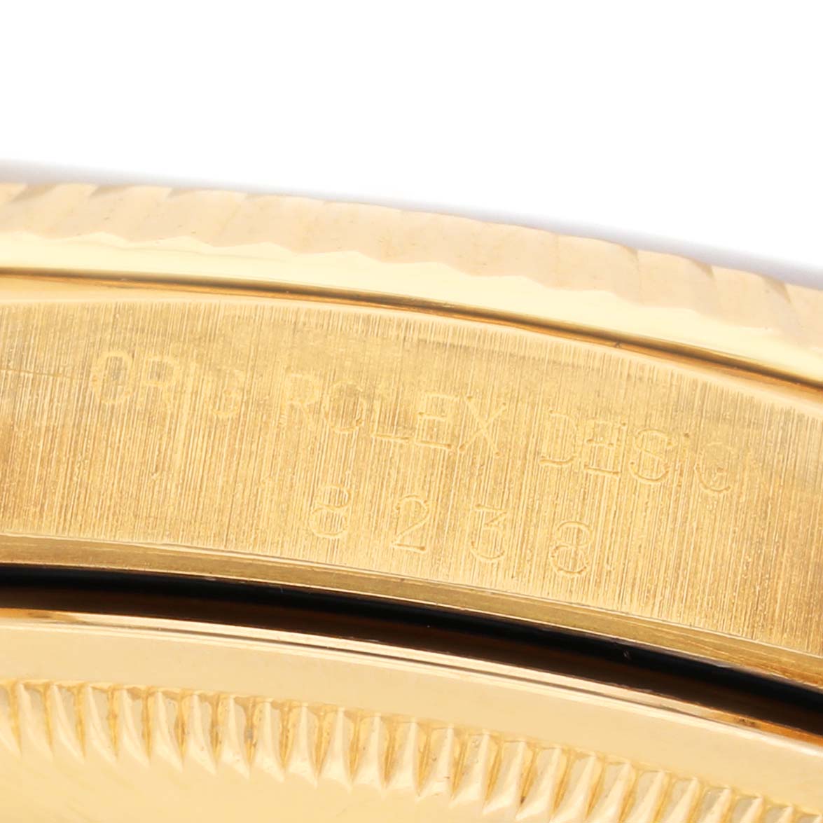 The image shows a close-up of the engraved bezel and edge of the gold case of the Rolex President 18238 Mens Yellow Gold Champagne Dial model.