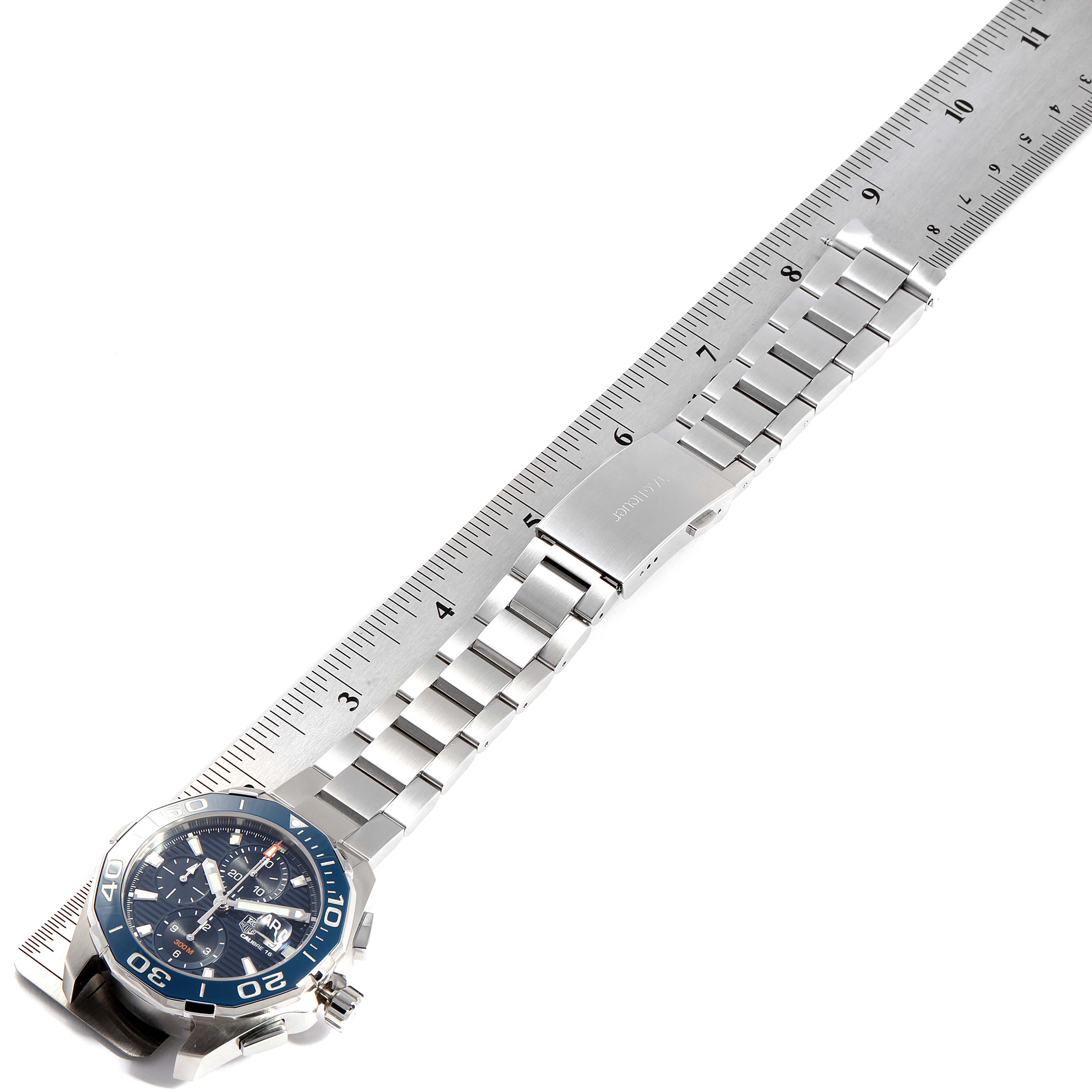 The image shows a Tag Heuer Aquaracer CAY211B.BA0927  Men's Stainless Steel Blue Dial CAY211B.BA0927  Men's Stainless Steel Blue Dial watch horizontally, displaying its bracelet and clasp next to a ruler for size reference.