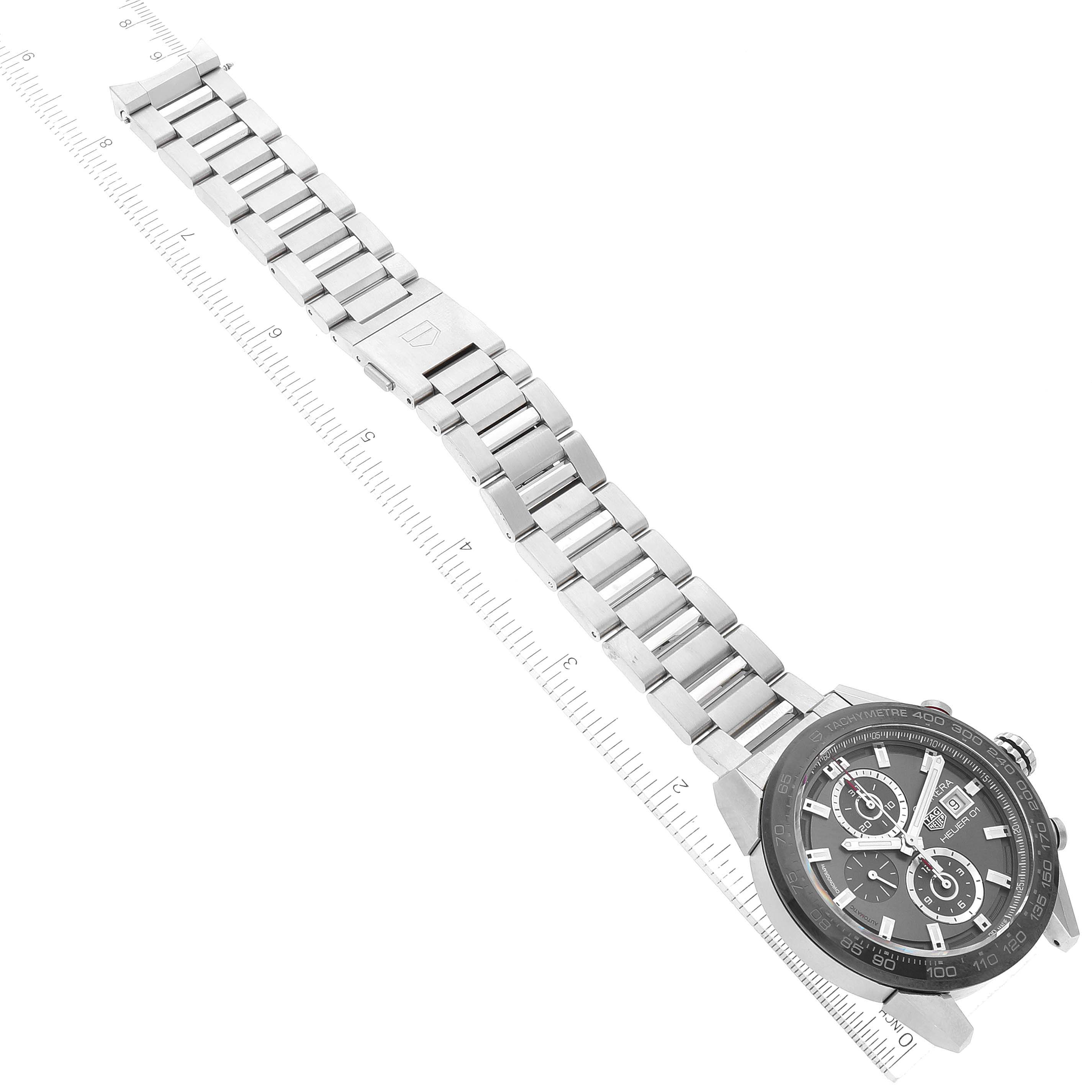 The image shows a top view of a Tag Heuer Carrera CAR201W.BA0714 Men's Stainless Steel Black Dial CAR201W.BA0714 Men's Stainless Steel Black Dial watch with its stainless steel band extended and aligned with a ruler.