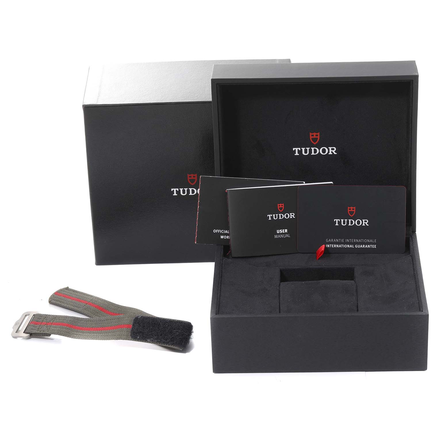 The image shows the packaging and accessories for a Tudor Pelagos M25717N-0001 Men
s Titanium Black Dial M25717N-0001 Men
s Titanium Black Dial watch, including the box, manuals, and a strap.