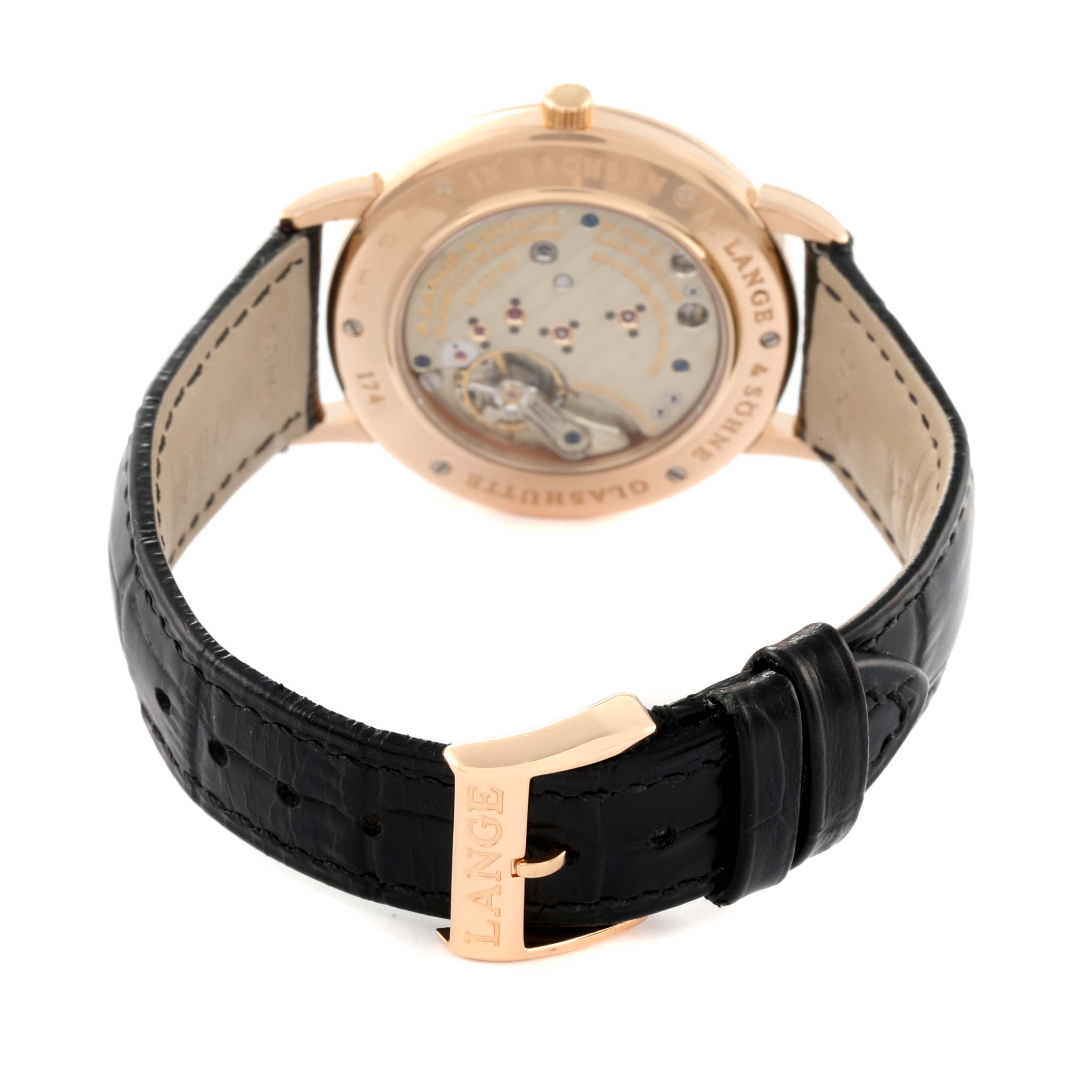 The image shows the rear view of the Saxonia model by A. Lange & Söhne, highlighting the watch's movement and black leather strap.