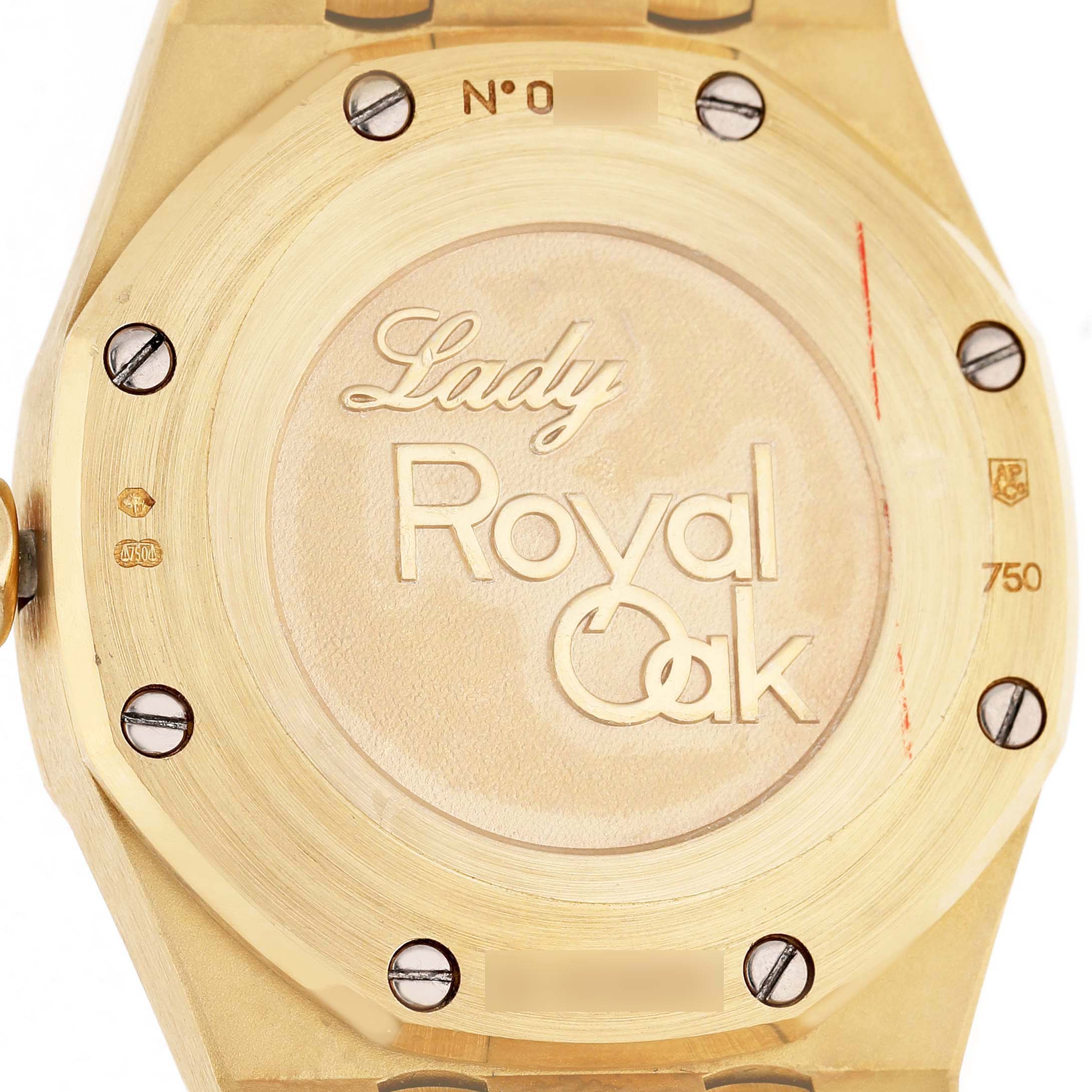 The image shows the back of an Audemars Piguet Royal Oak 77321 Women's Yellow Gold Mother of Pearl Dial Lady watch, highlighting the engraved details and screws.