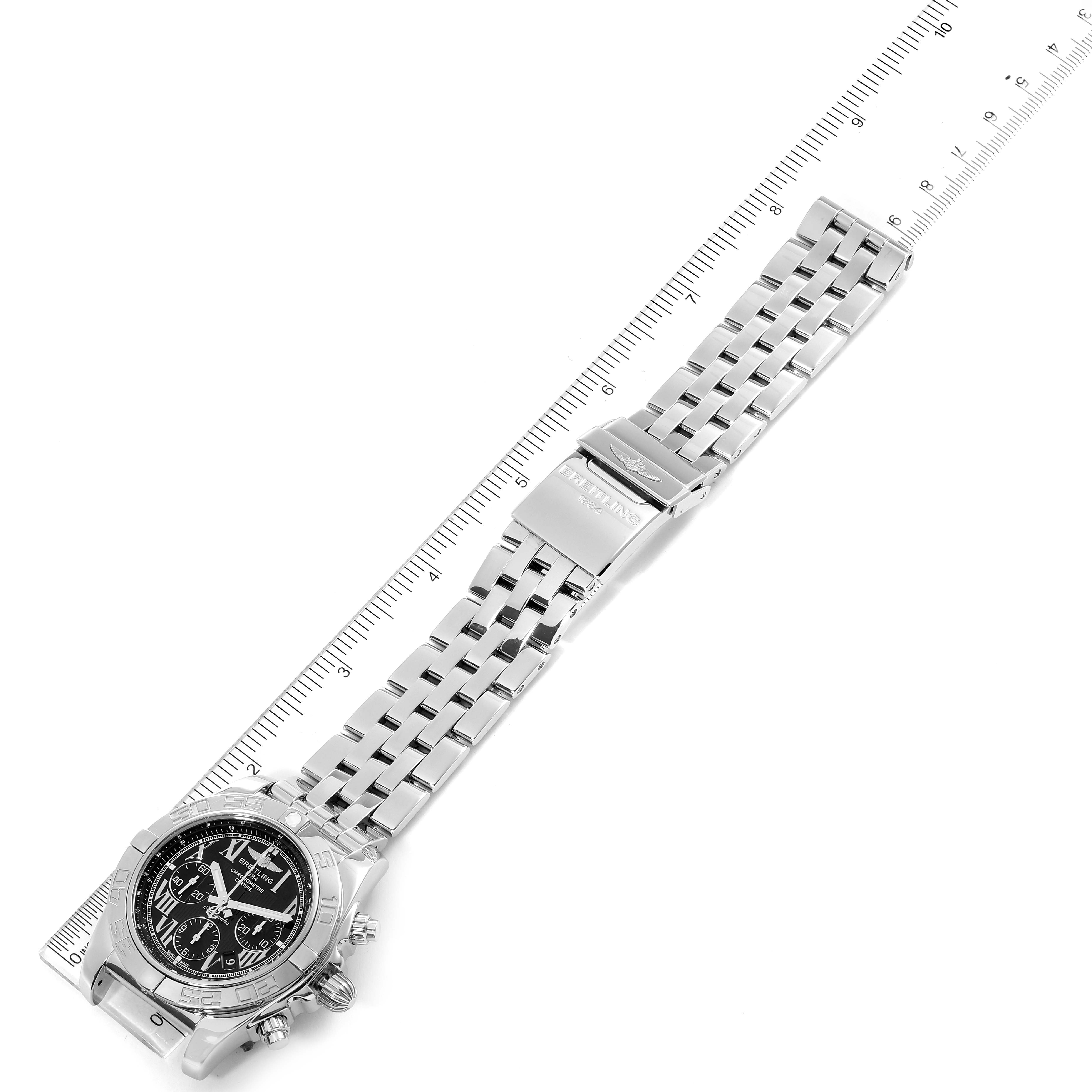 The Breitling Chronomat AB0110 Men's Stainless Steel Black Dial AB0110 Men's Stainless Steel Black Dial watch is shown from an overhead angle with its bracelet fully extended next to a ruler.
