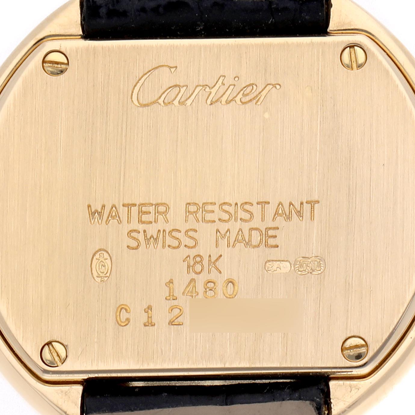 The image shows the back of a Cartier Tortue WB600851 Women
s Yellow Gold Silver Dial WB600851 Women
s Yellow Gold Silver Dial watch, displaying engravings and screws.