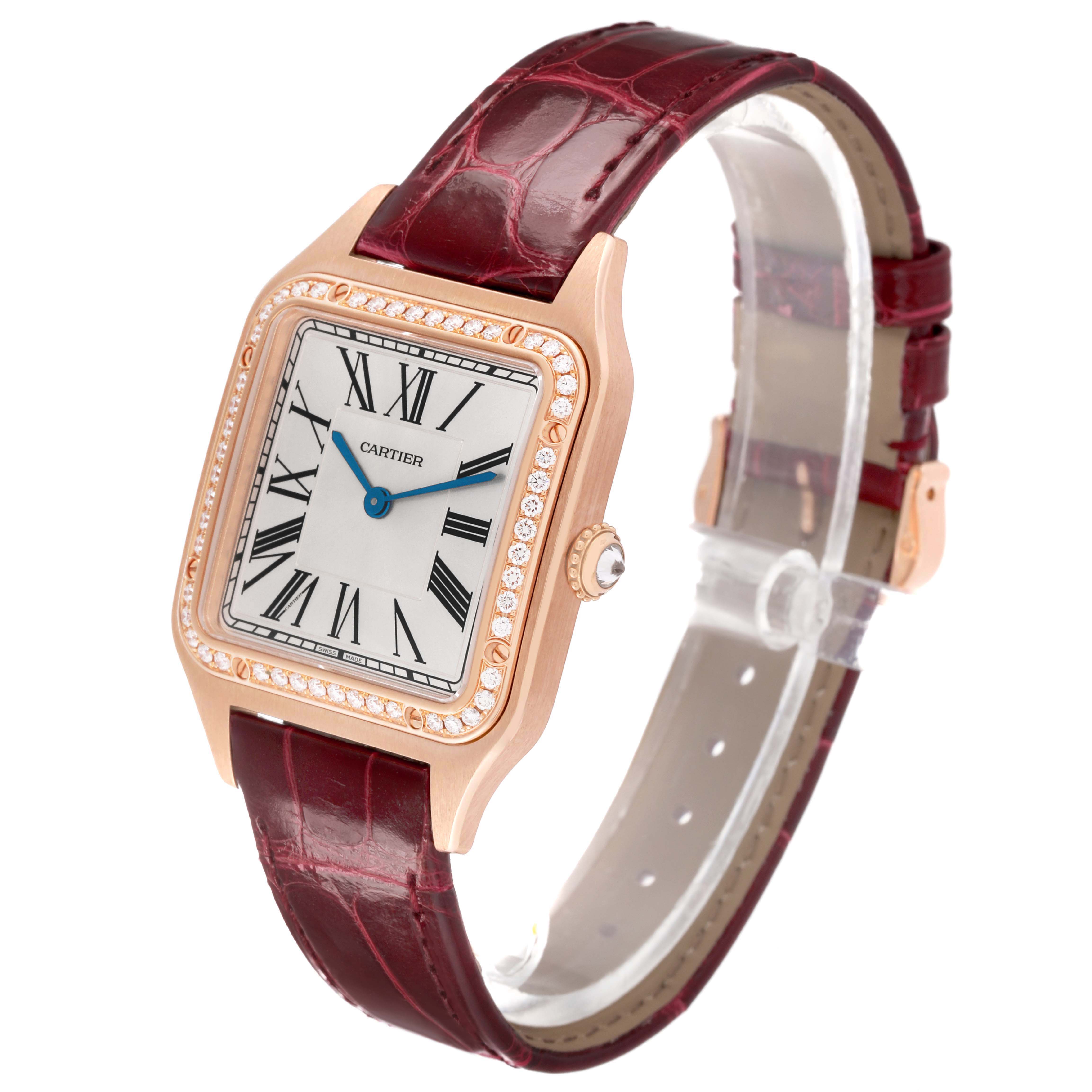 The Cartier Santos WJSA0016 Women's Rose Gold Silver Dial watch is shown at an angle highlighting its face, bezel, crown, and maroon leather strap.