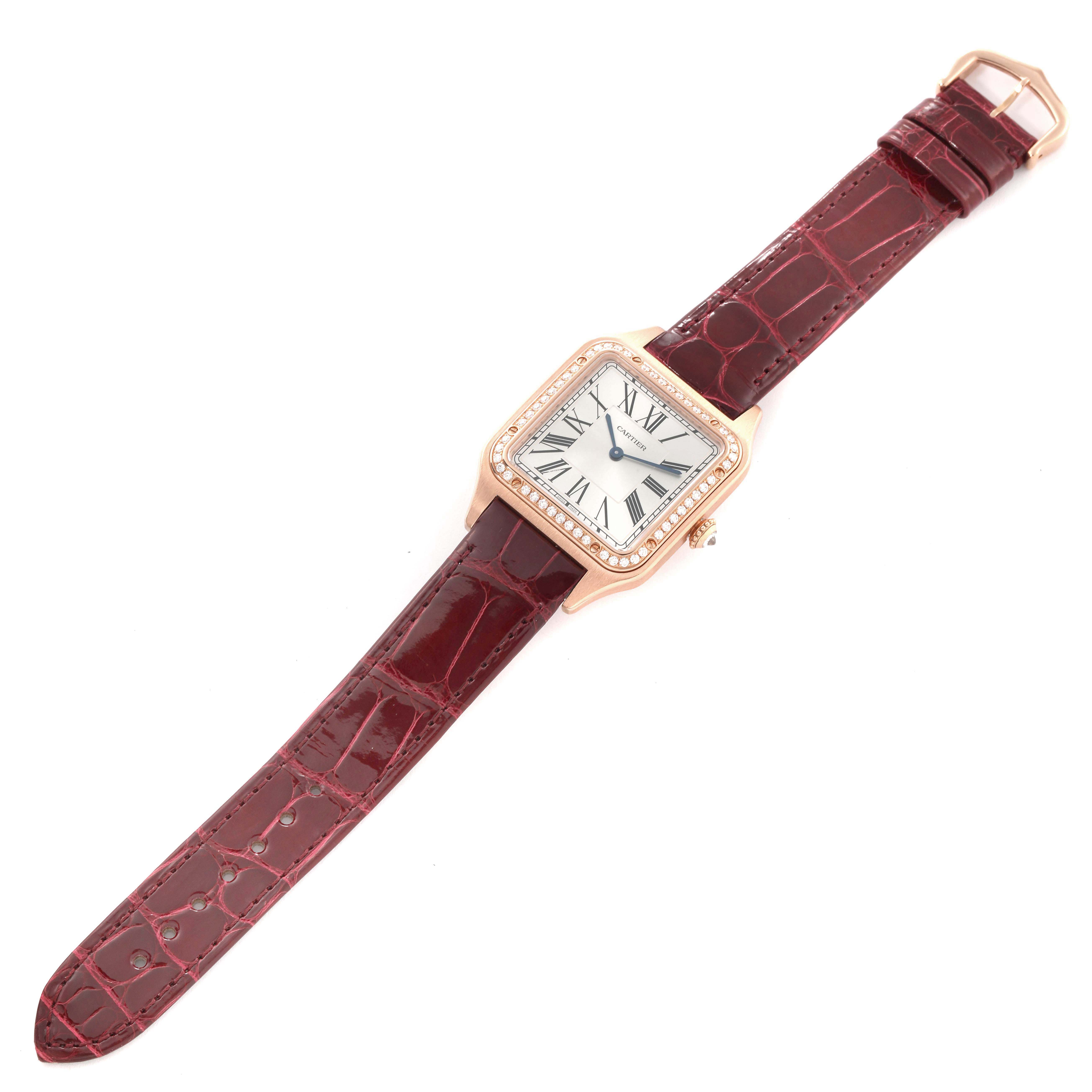The Cartier Santos WJSA0016 Women's Rose Gold Silver Dial watch is shown from a top-down angle featuring its square face, leather strap, and visible bezel detailing.