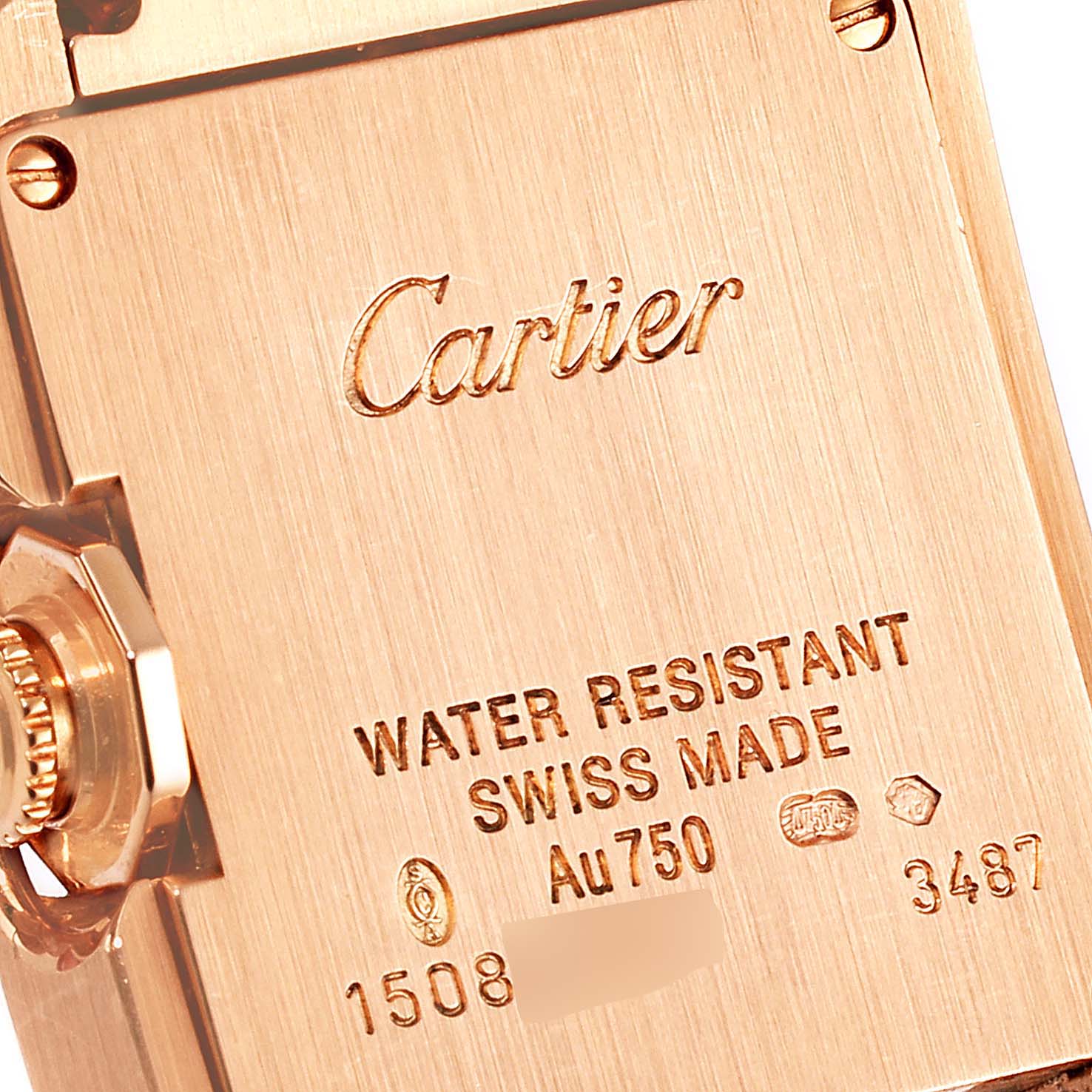 This image shows the back case and crown of the Cartier Tank Anglaise WT100002 Women
s Rose Gold Silver Dial WT100002 Women
s Rose Gold Silver Dial watch, engraved with branding and specifications.