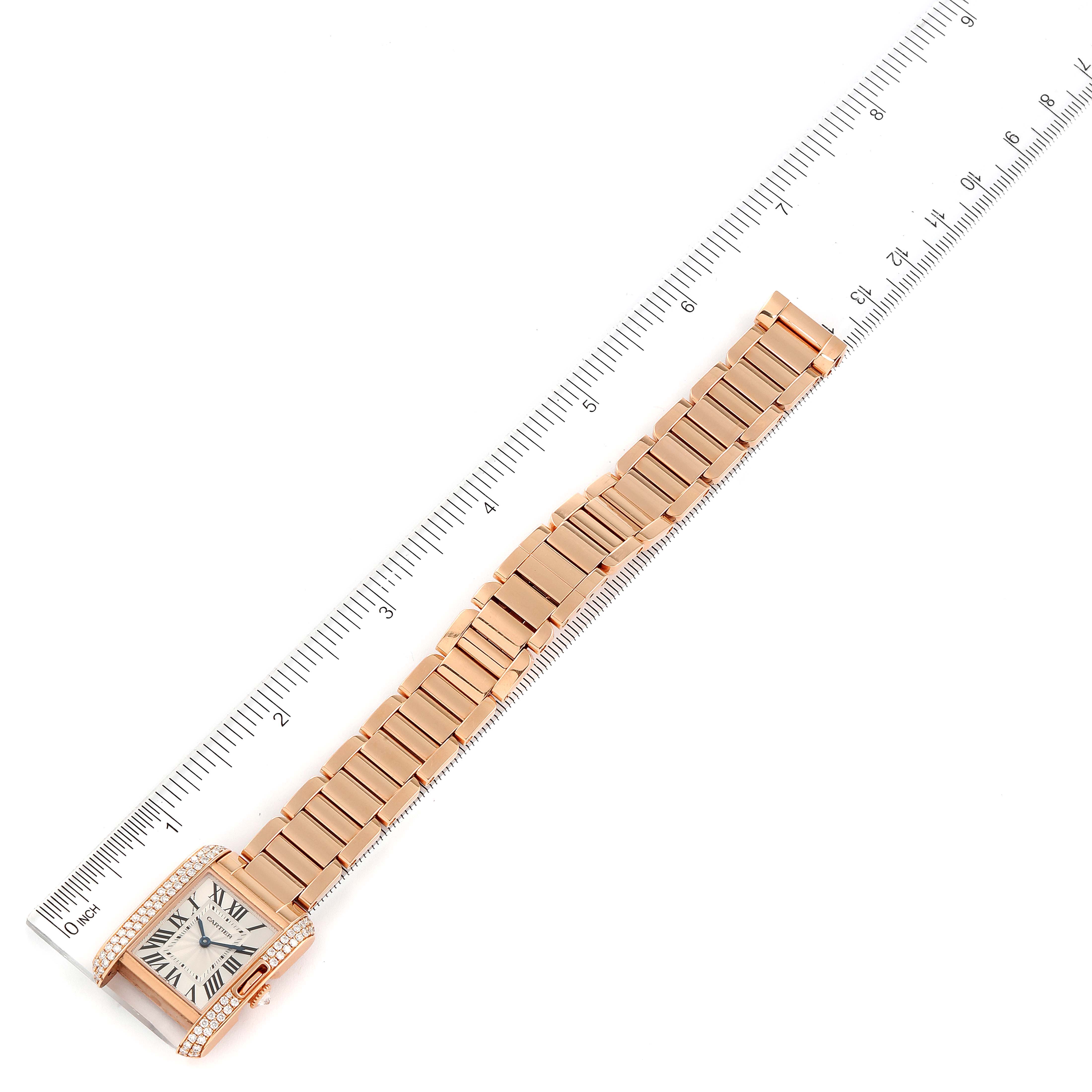 The Cartier Tank Anglaise WT100002 Women
s Rose Gold Silver Dial WT100002 Women
s Rose Gold Silver Dial watch is shown laid flat alongside a ruler, highlighting its bracelet and diamond-embellished case.