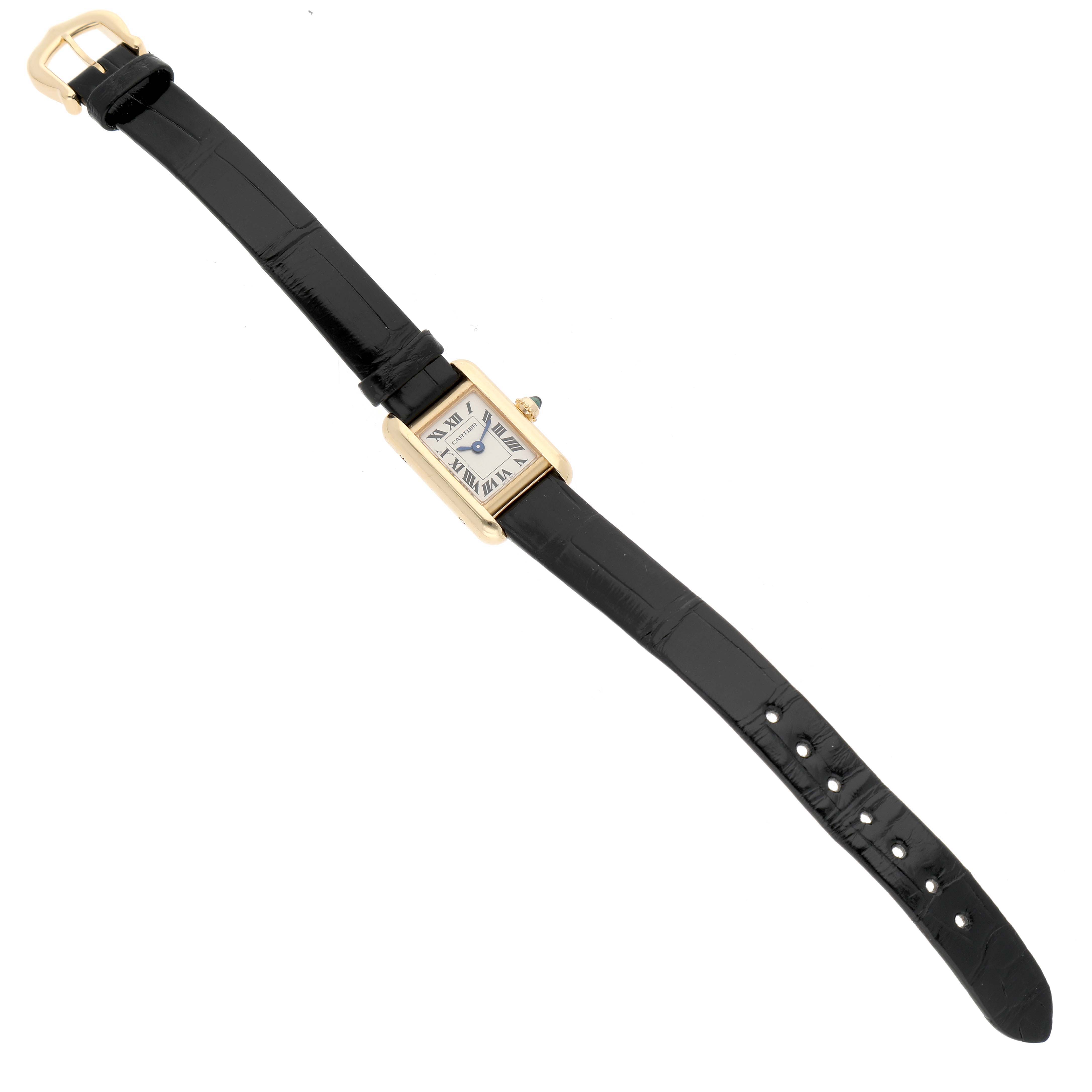 The Cartier Tank Louis Women's Yellow Gold Silver Dial watch is shown from a top-down angle, displaying the face, gold case, and black leather strap.