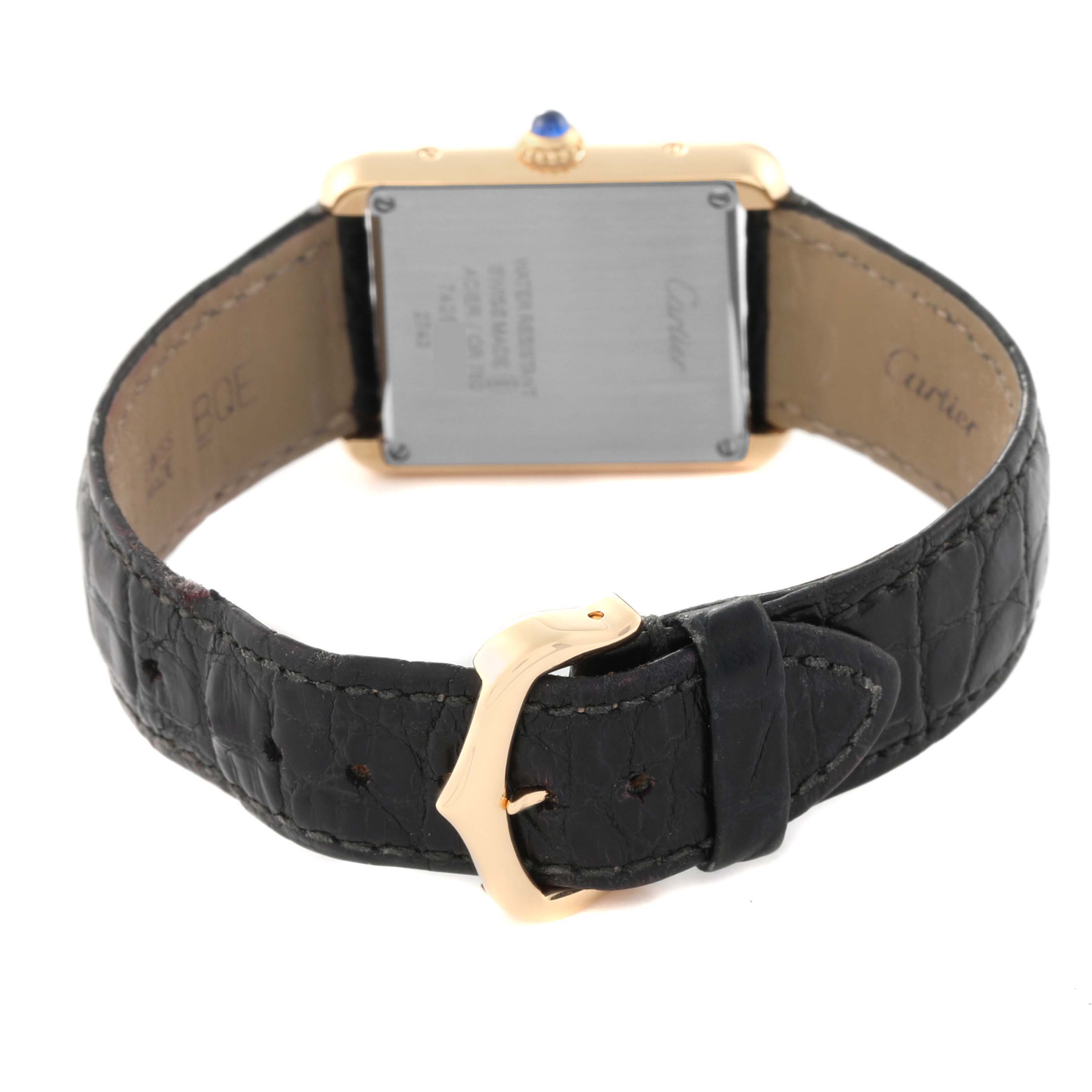 The image shows the back case and strap of a Cartier Tank Solo W1018755 Women
s Steel and Gold (two tone) Silver Dial W1018755 Women
s Steel and Gold (two tone) Silver Dial watch, featuring a black leather band and gold buckle.