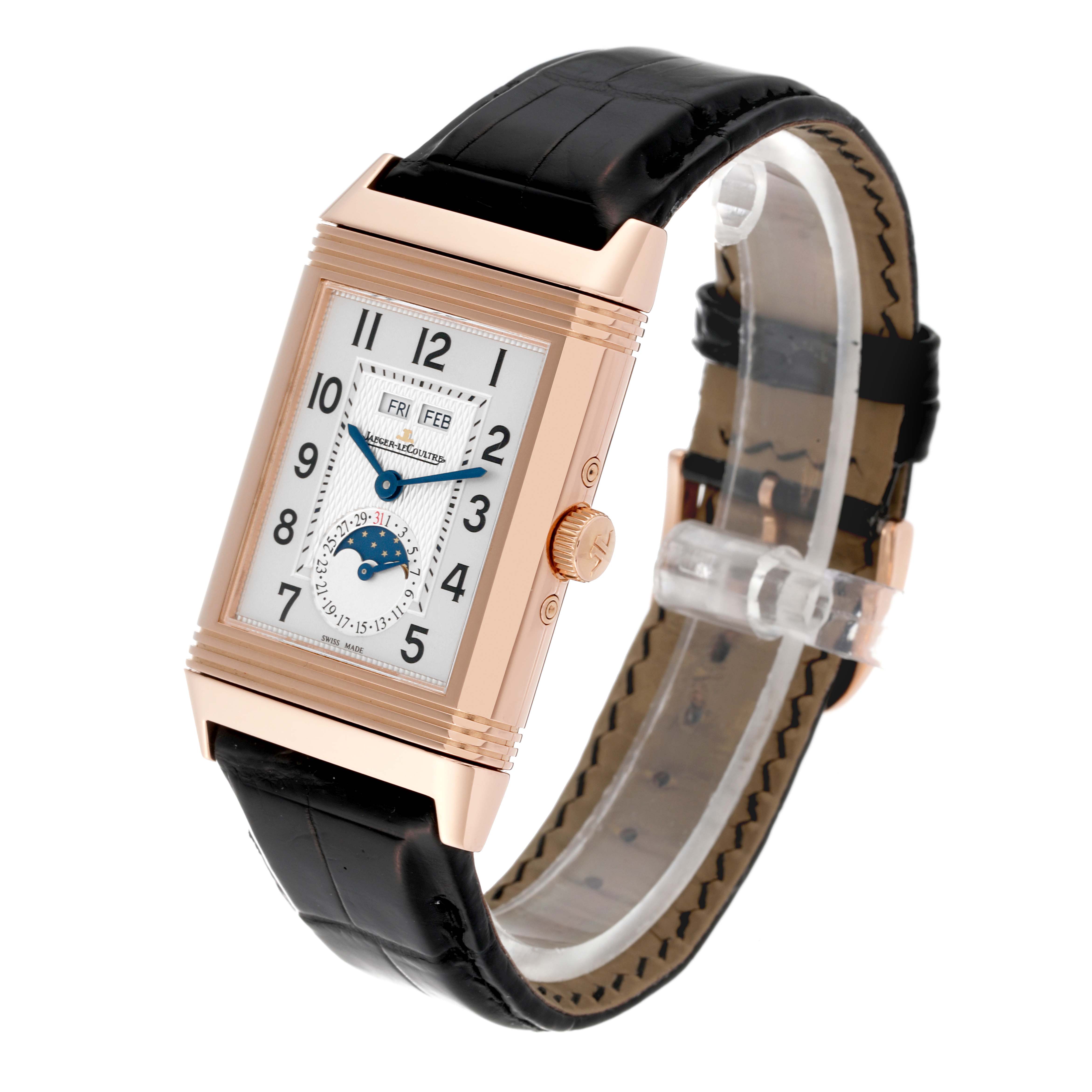 The Jaeger-LeCoultre Reverso watch is shown at a three-quarter angle, highlighting its rectangular dial, crown, and leather strap.