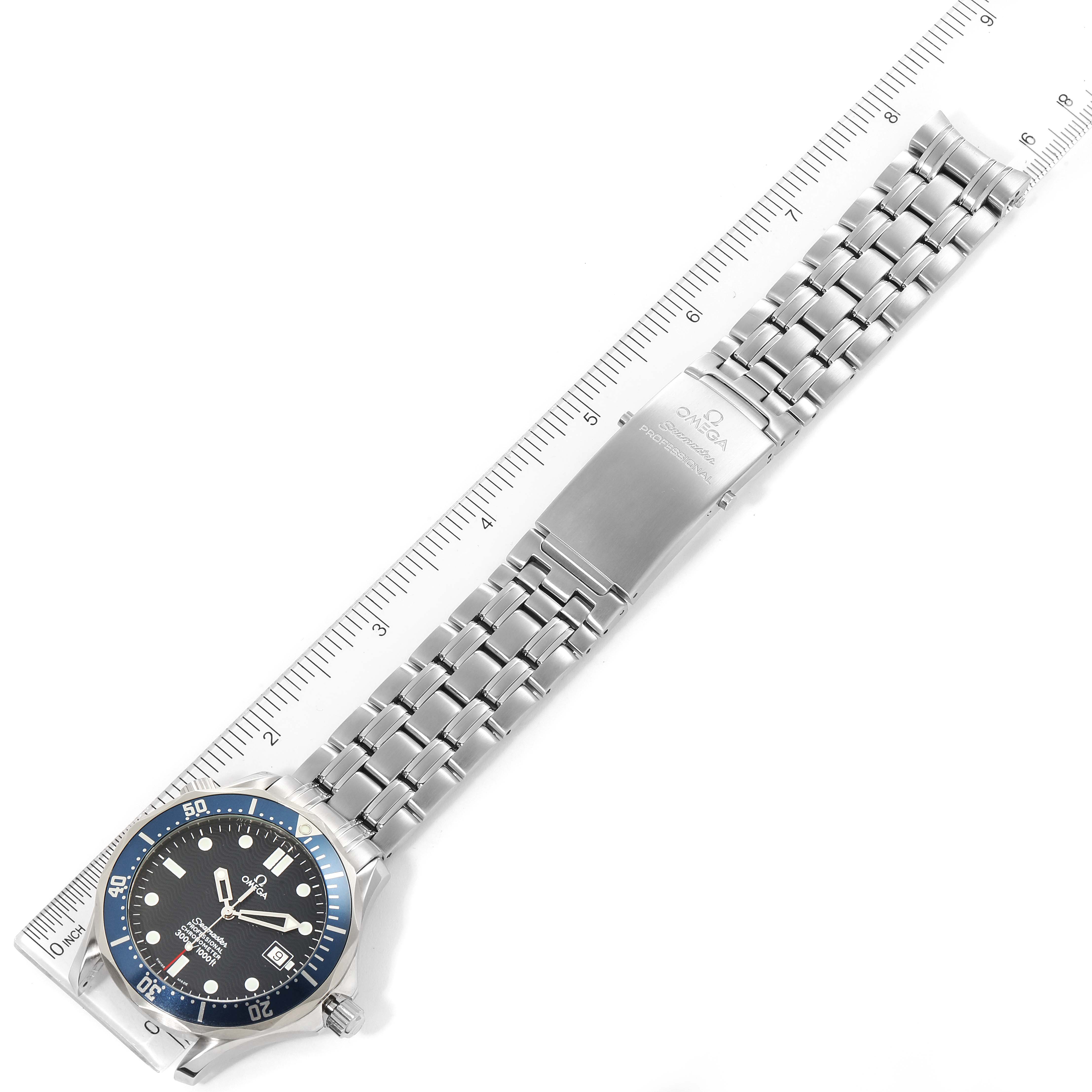 The image shows an overhead view of an Omega Seamaster 2531.80.00 Men
s Stainless Steel Blue Dial 2531.80.00 Men
s Stainless Steel Blue Dial watch, including the face, bezel, bracelet, and clasp, along with a measurement ruler.