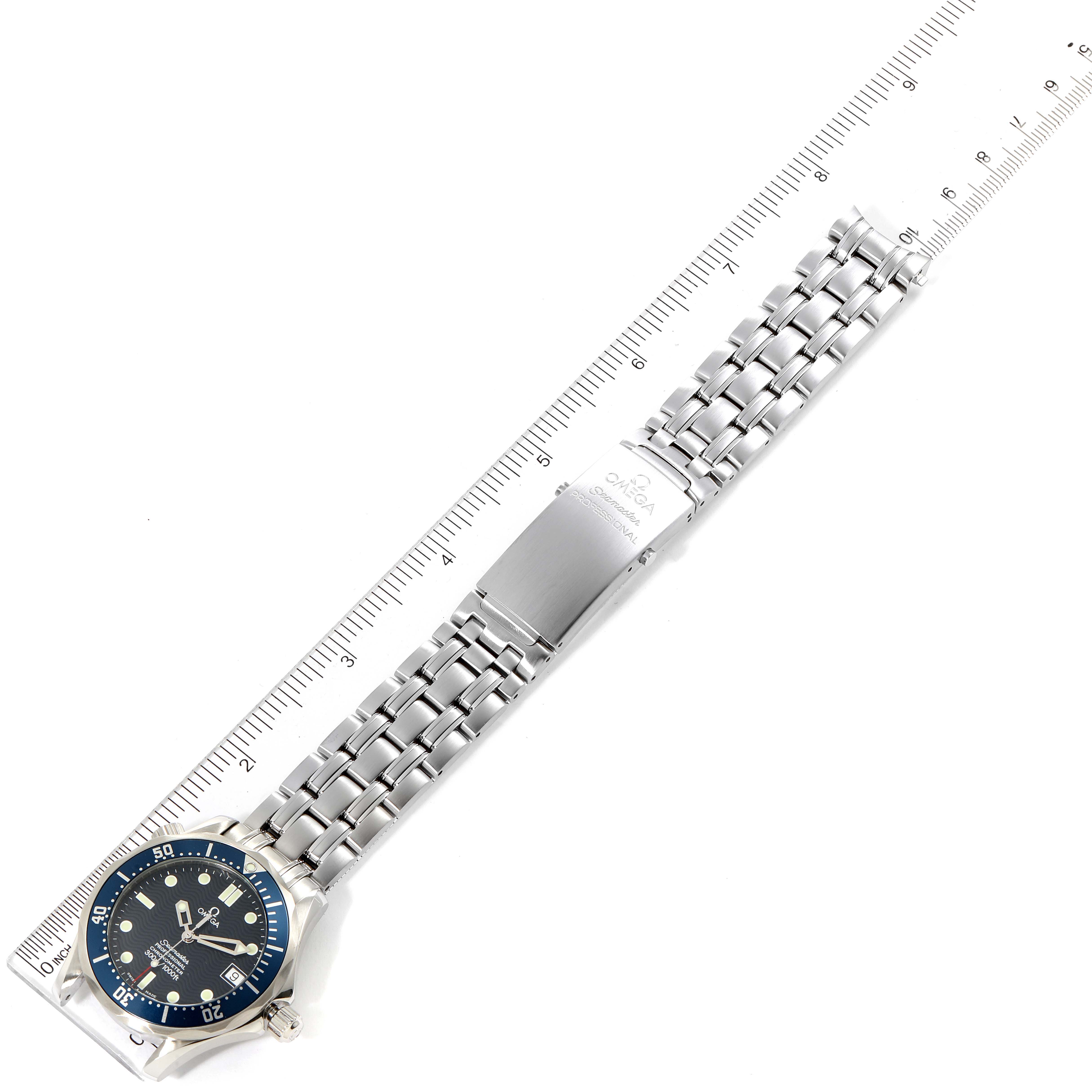 The image shows an overhead view of a Seamaster model by Omega, displaying the face, bracelet, and clasp next to a ruler for scale.