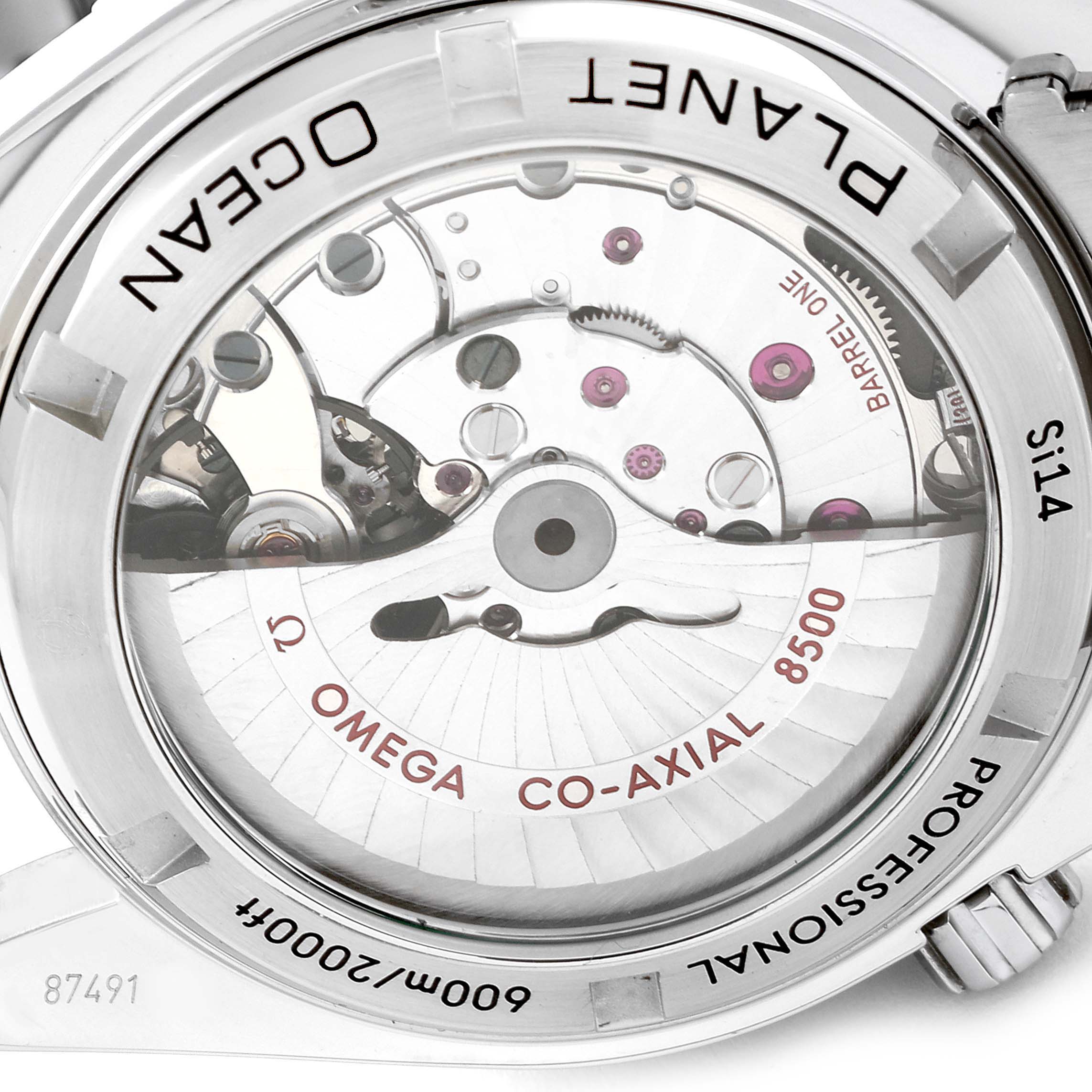 The image shows the back view of the Planet Ocean Omega watch, highlighting its co-axial movement and internal mechanisms.