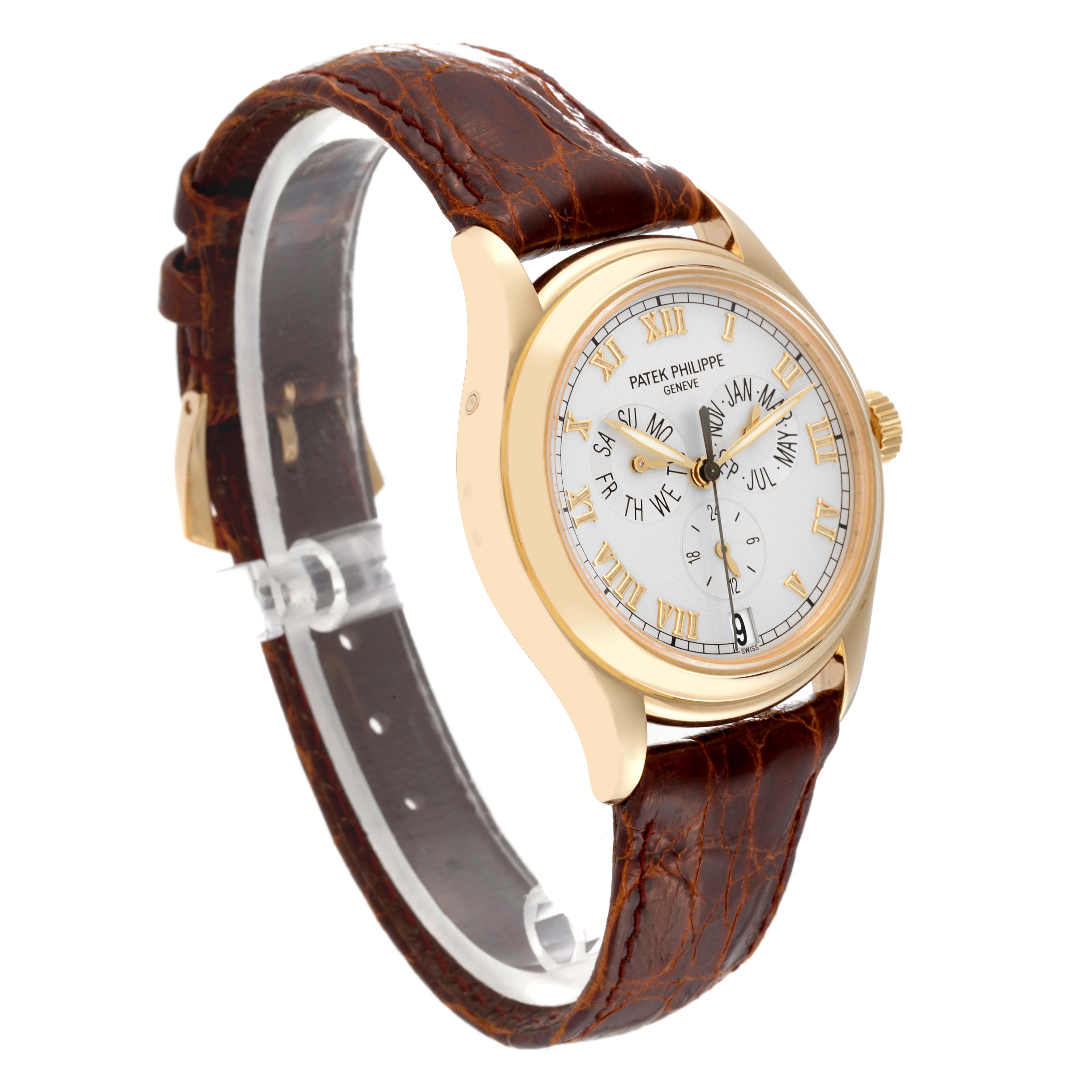 The image shows a side angle of the Patek Philippe Complications 5035J-001 Men
s Yellow Gold Silver Dial 5035J-001 Men
s Yellow Gold Silver Dial model, highlighting the dial, case, crown, and brown leather strap.