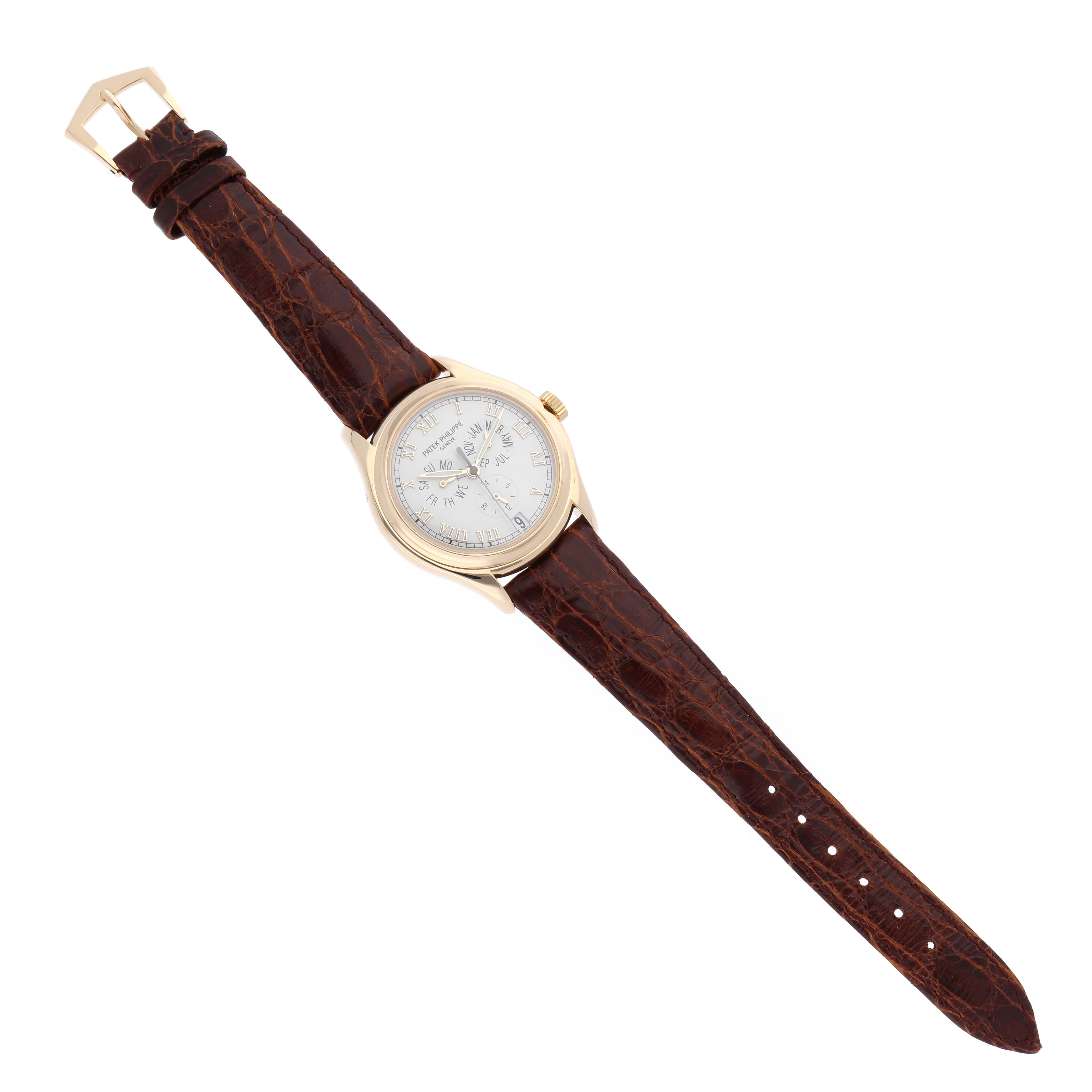 The Complications model by Patek Philippe is shown from a top-down angle, displaying the face, bezel, crown, and brown leather strap.