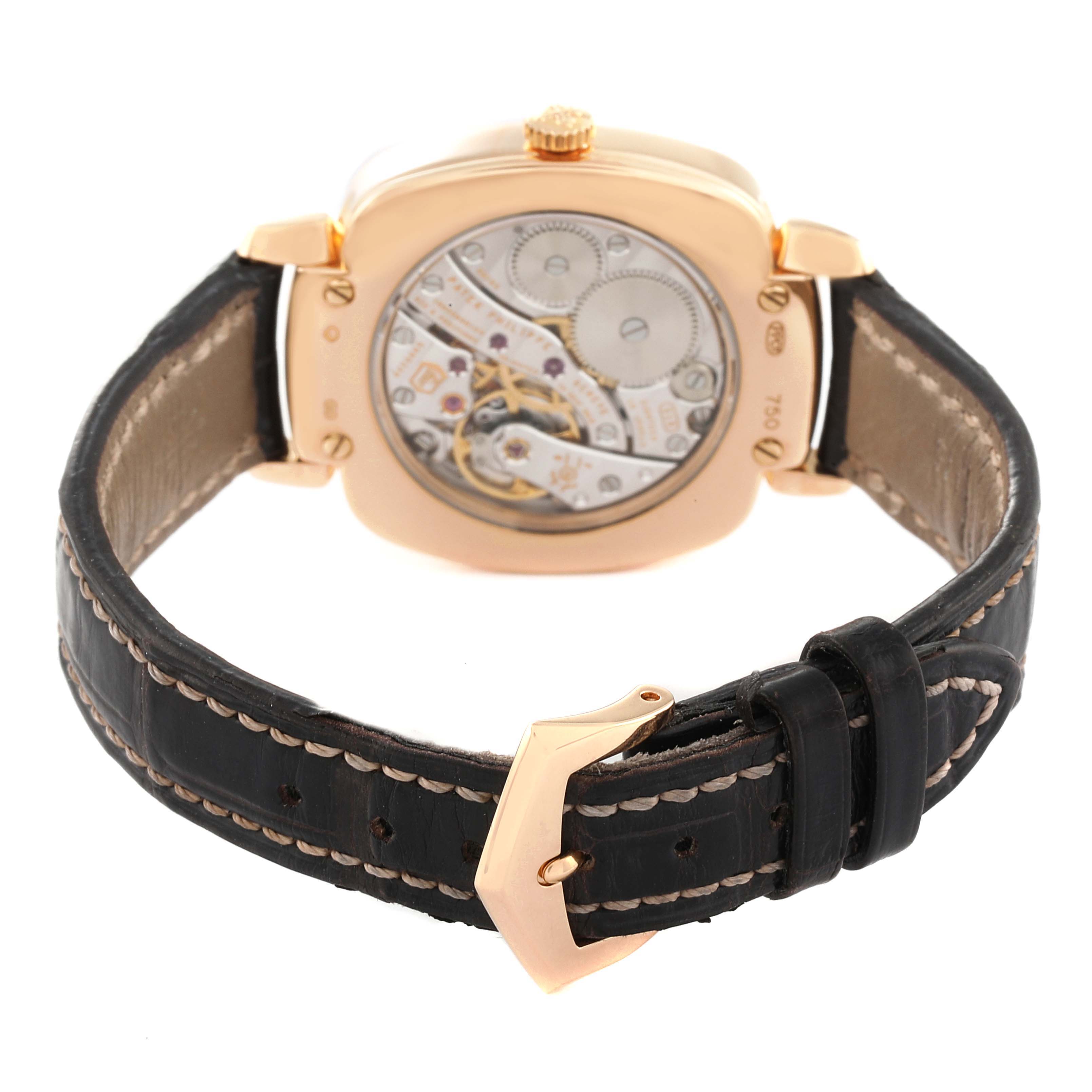 The image shows the back view of a Patek Philippe Gondolo 7041R-001 Women
s Rose Gold Silver Dial 7041R-001 Women
s Rose Gold Silver Dial watch highlighting its movement and black leather strap with a gold buckle.