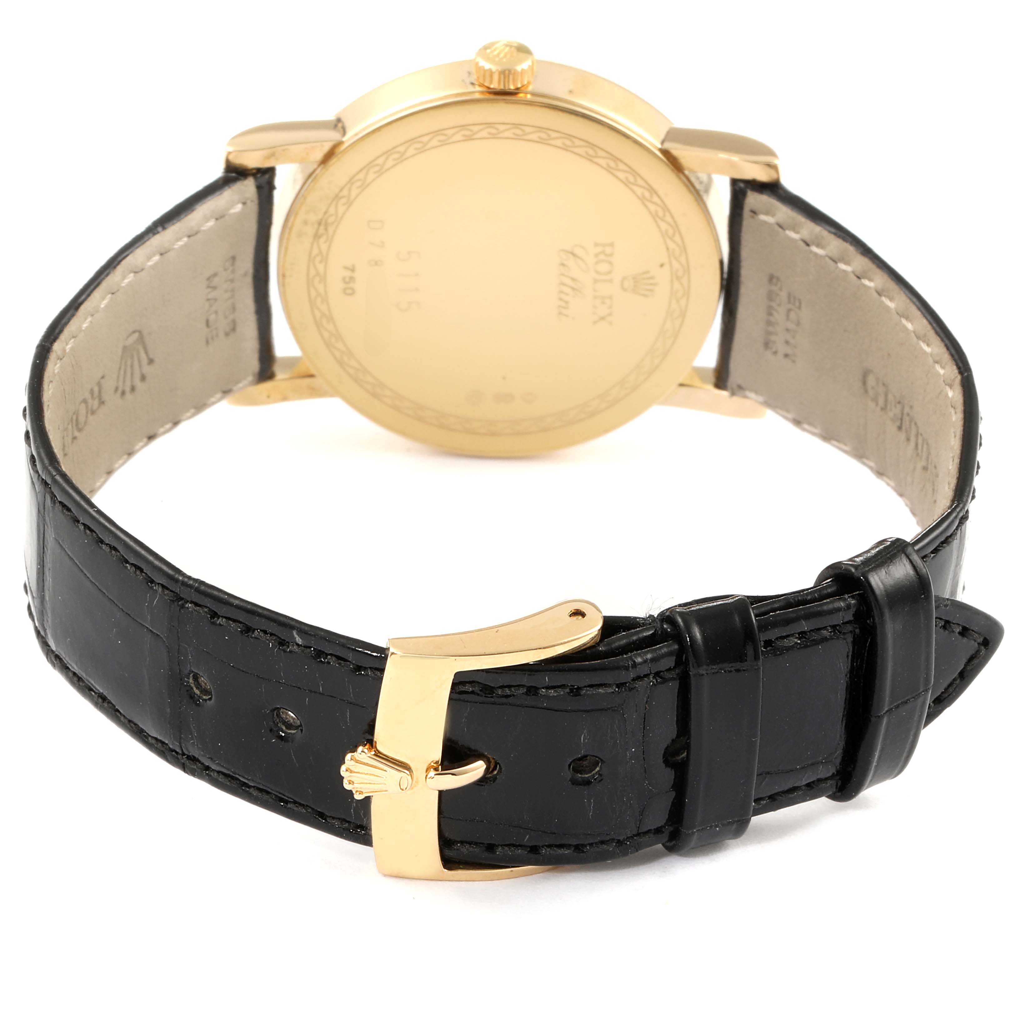 The Rolex Cellini 5115 Men's Yellow Gold Silver Dial 5115 Men's Yellow Gold Silver Dial watch is shown from the back, revealing its gold case, black leather strap, and gold buckle.