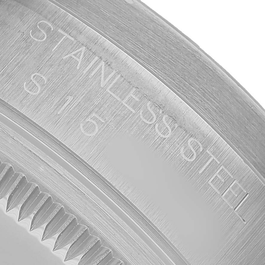 The image shows a close-up of the stainless steel casing or back of a Rolex Date 15210 Men's Stainless Steel Blue Dial watch, angled to display the engraved text.