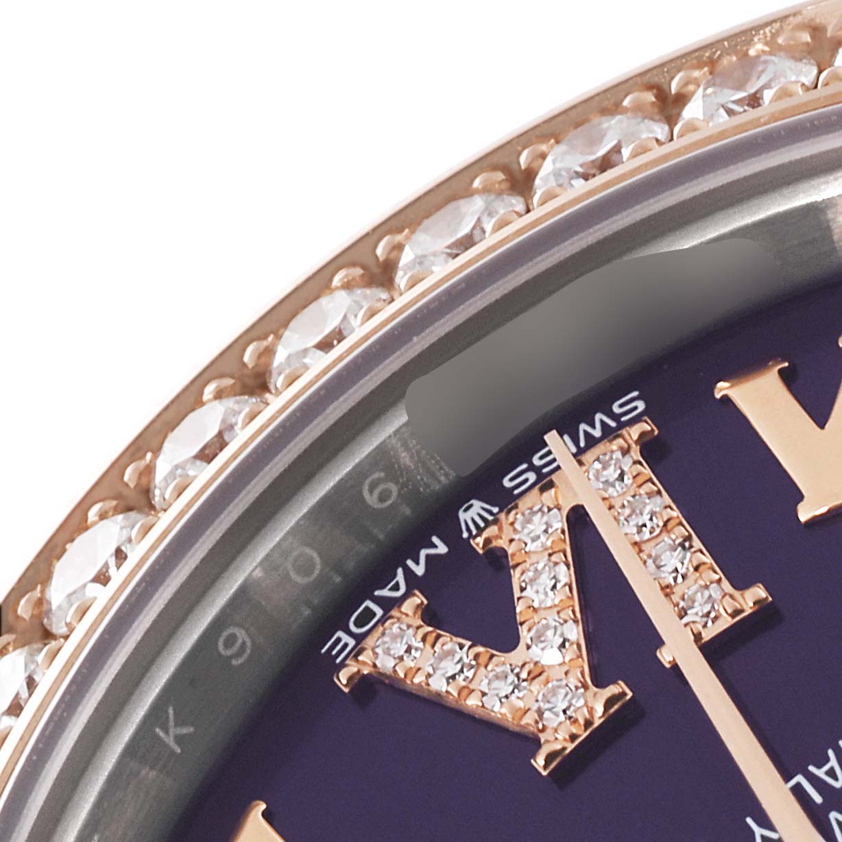 This close-up image of a Rolex Mid-Size 278381 Women's Steel and Gold (two tone) Purple Dial 278381 Women's Steel and Gold (two tone) Purple Dial model shows the diamond-set bezel and part of the dial with a diamond-studded Roman numeral.