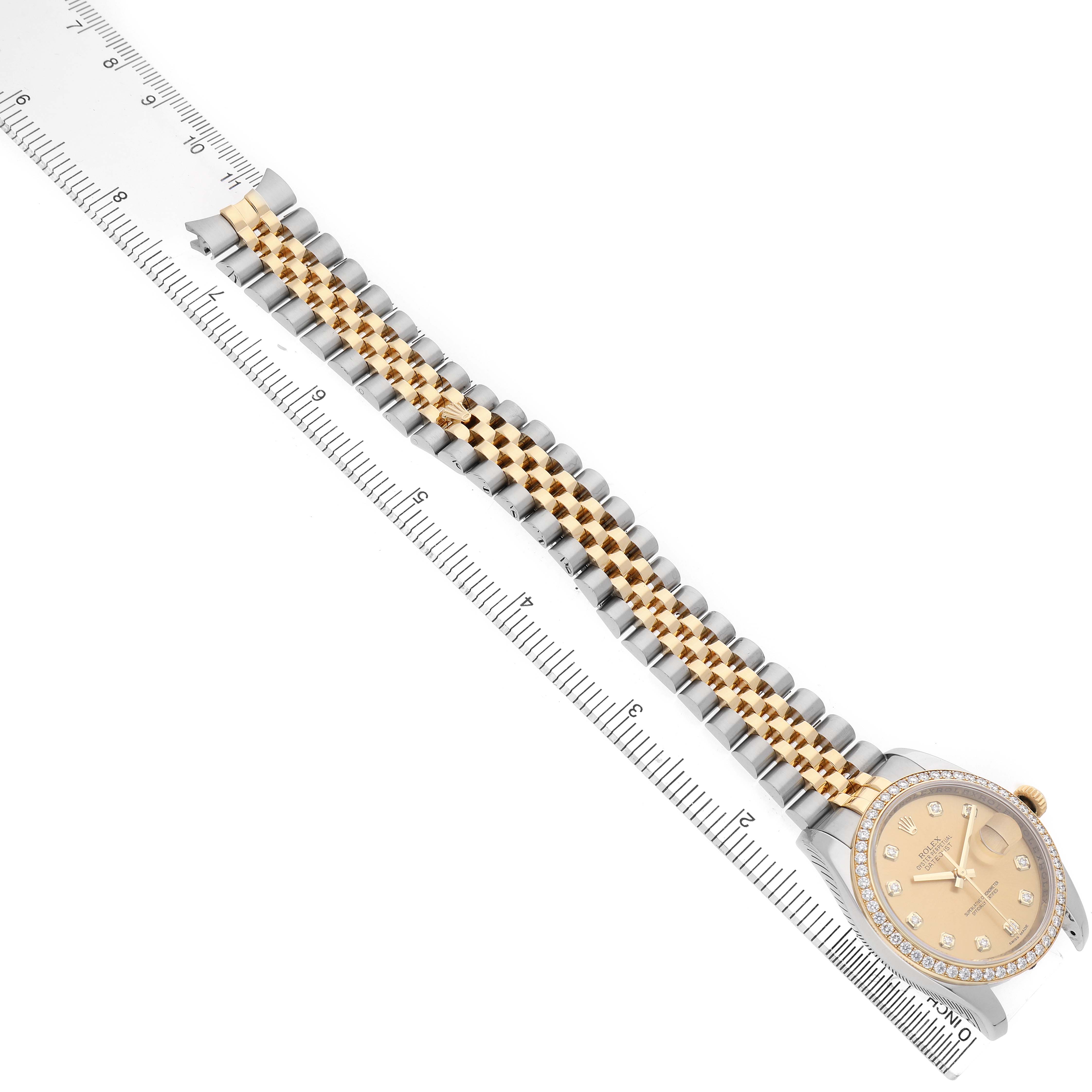 The Rolex Datejust 116243 Men's Stainless Steel Champagne Dial watch is shown from an oblique angle, showcasing the bracelet, dial, and bezel with a ruler for scale.