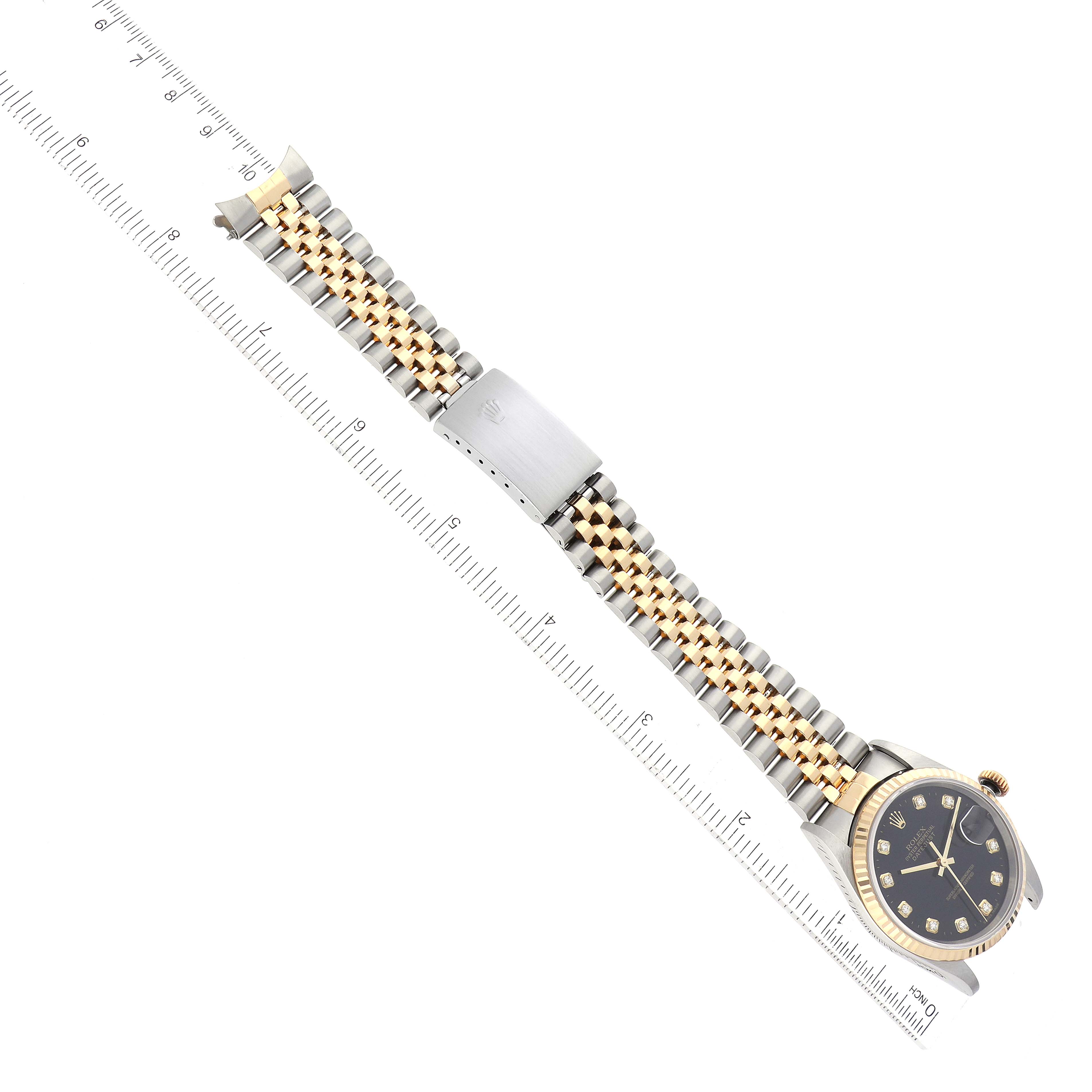 The image shows a Rolex Datejust 16233 Men's Steel and Gold (two tone) Black Dial 16233 Men's Steel and Gold (two tone) Black Dial watch laid flat, displaying its dial, bezel, bracelet, and clasp alongside a measuring ruler.